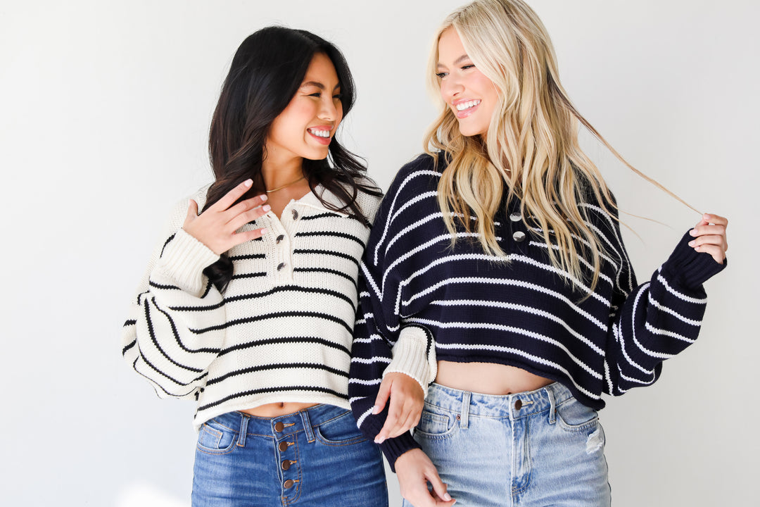 models wearing striped cropped collared sweaters in front of a white background.