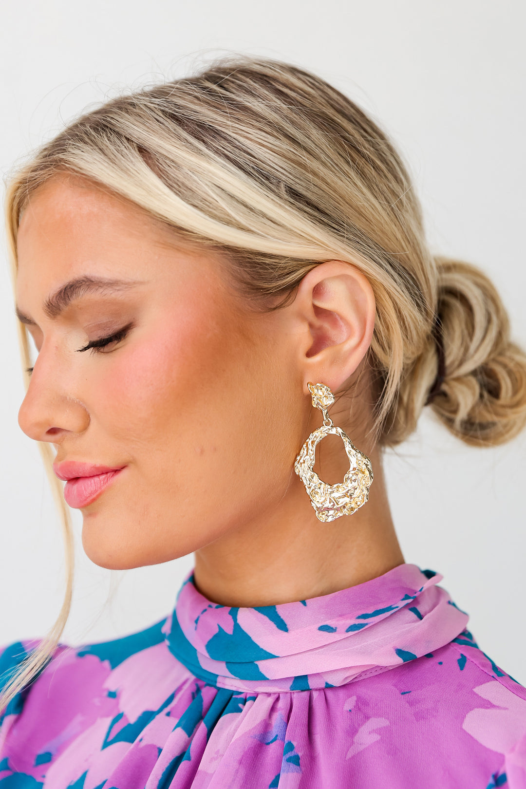 model wearing gold statement earrings