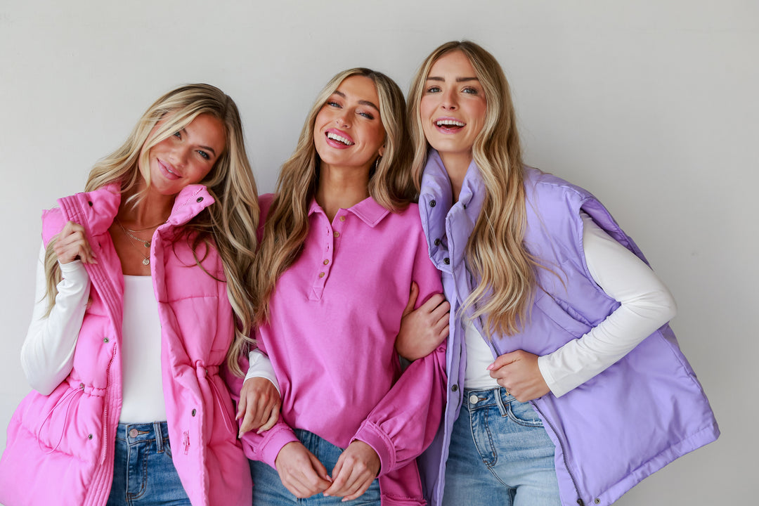 three models in bright pink and purple puffer vests