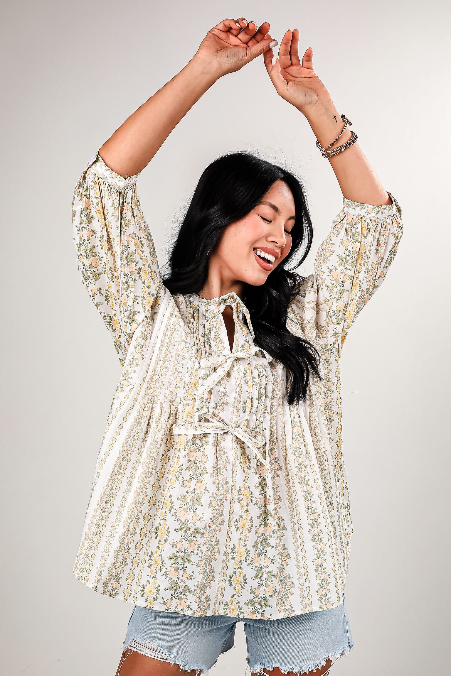 Woman wearing a floral blouse with a neutral background