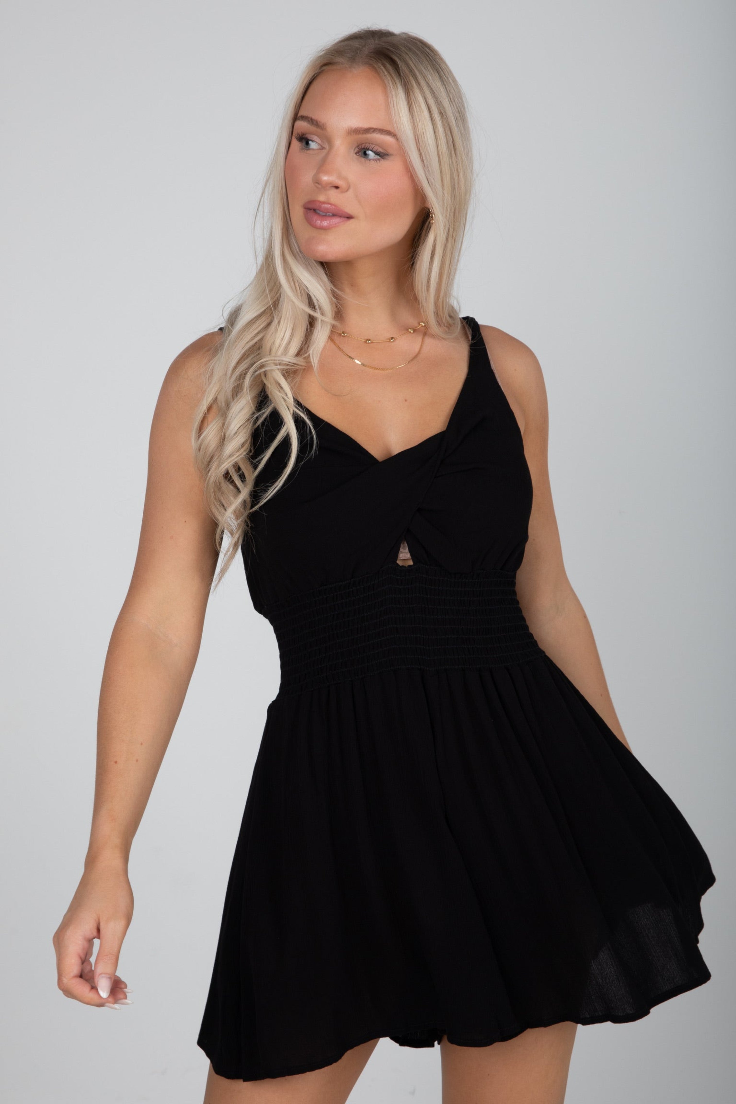 Woman wearing a black dress against a plain background