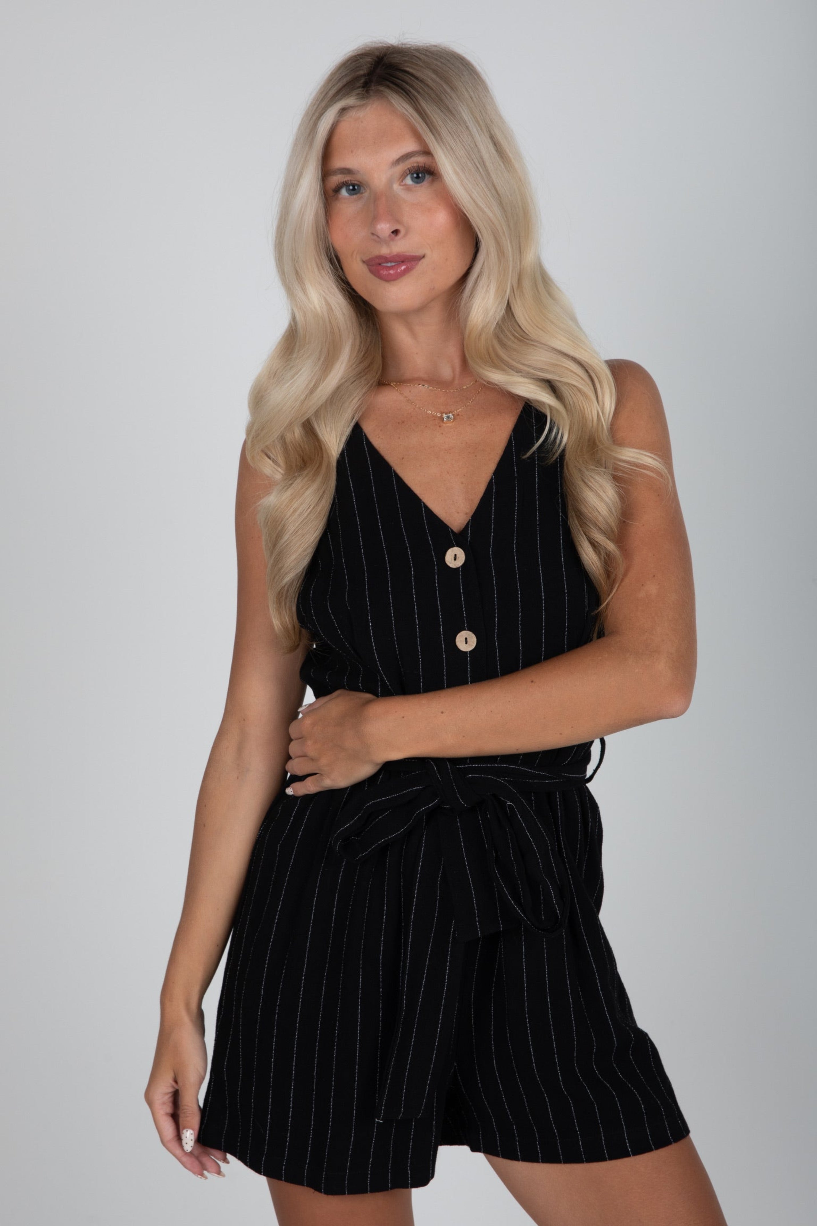 Woman wearing a black pinstripe dress against a plain background