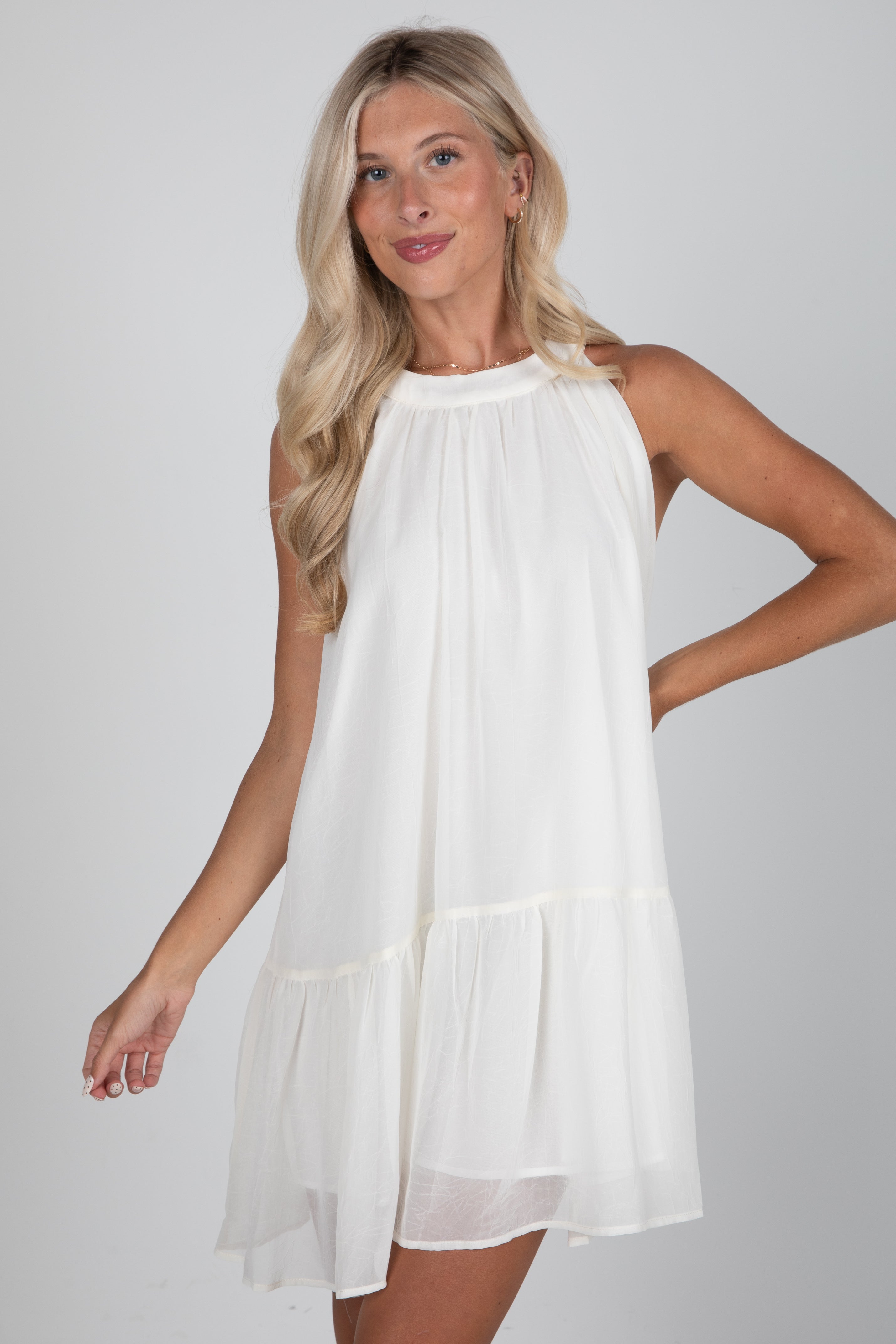 Woman wearing a white dress against a plain background