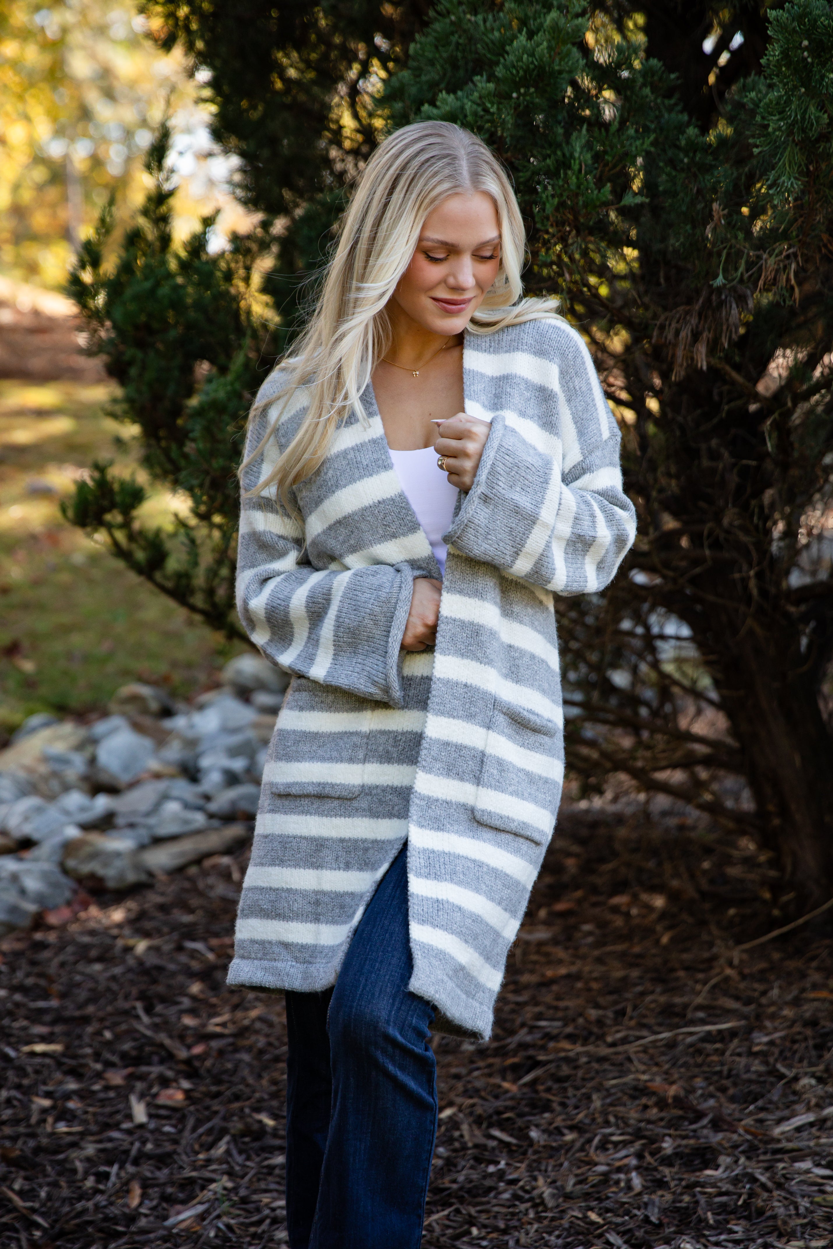 Woman wearing a long, striped cardigan in an outdoor setting