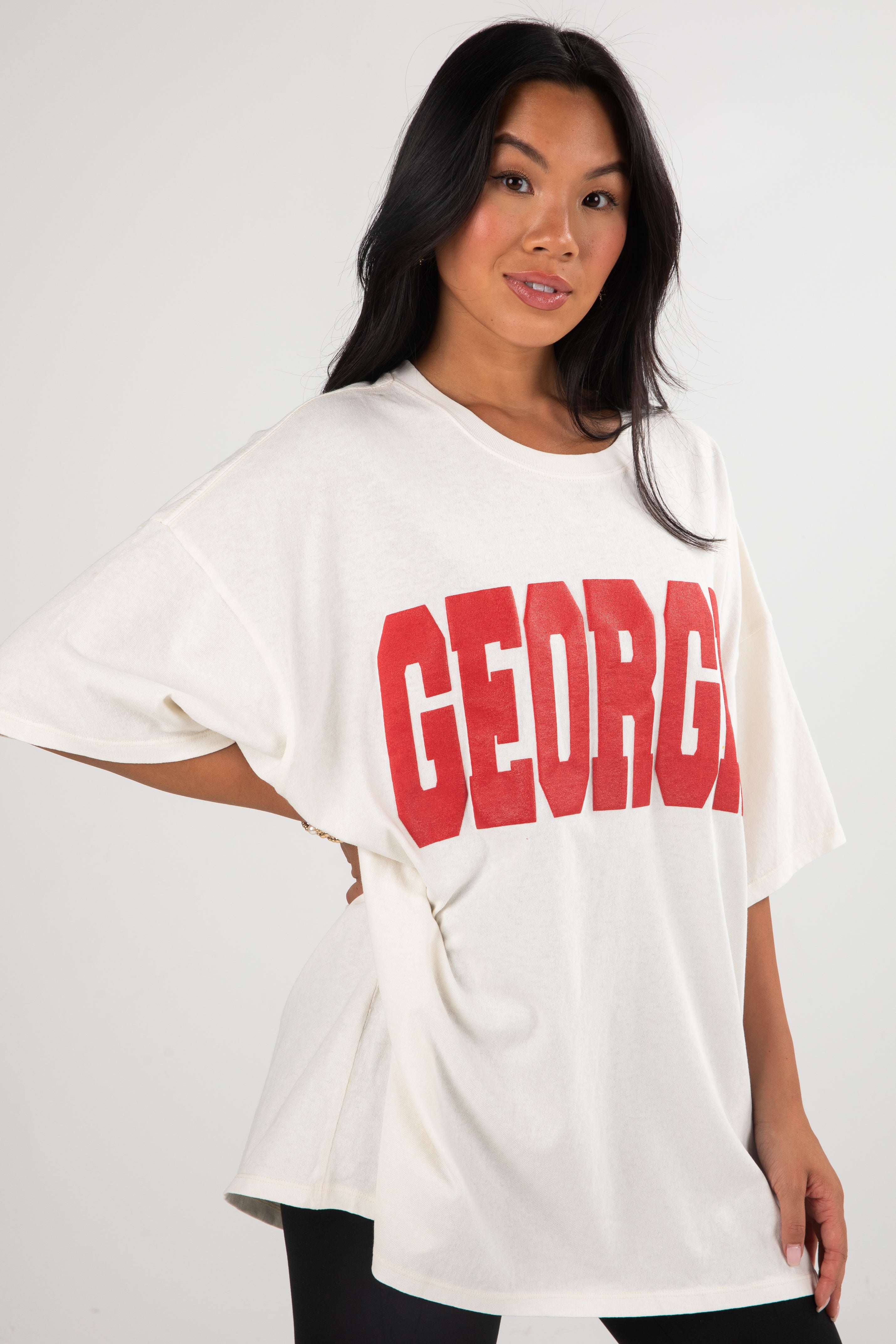 Woman wearing a white oversized t-shirt with &