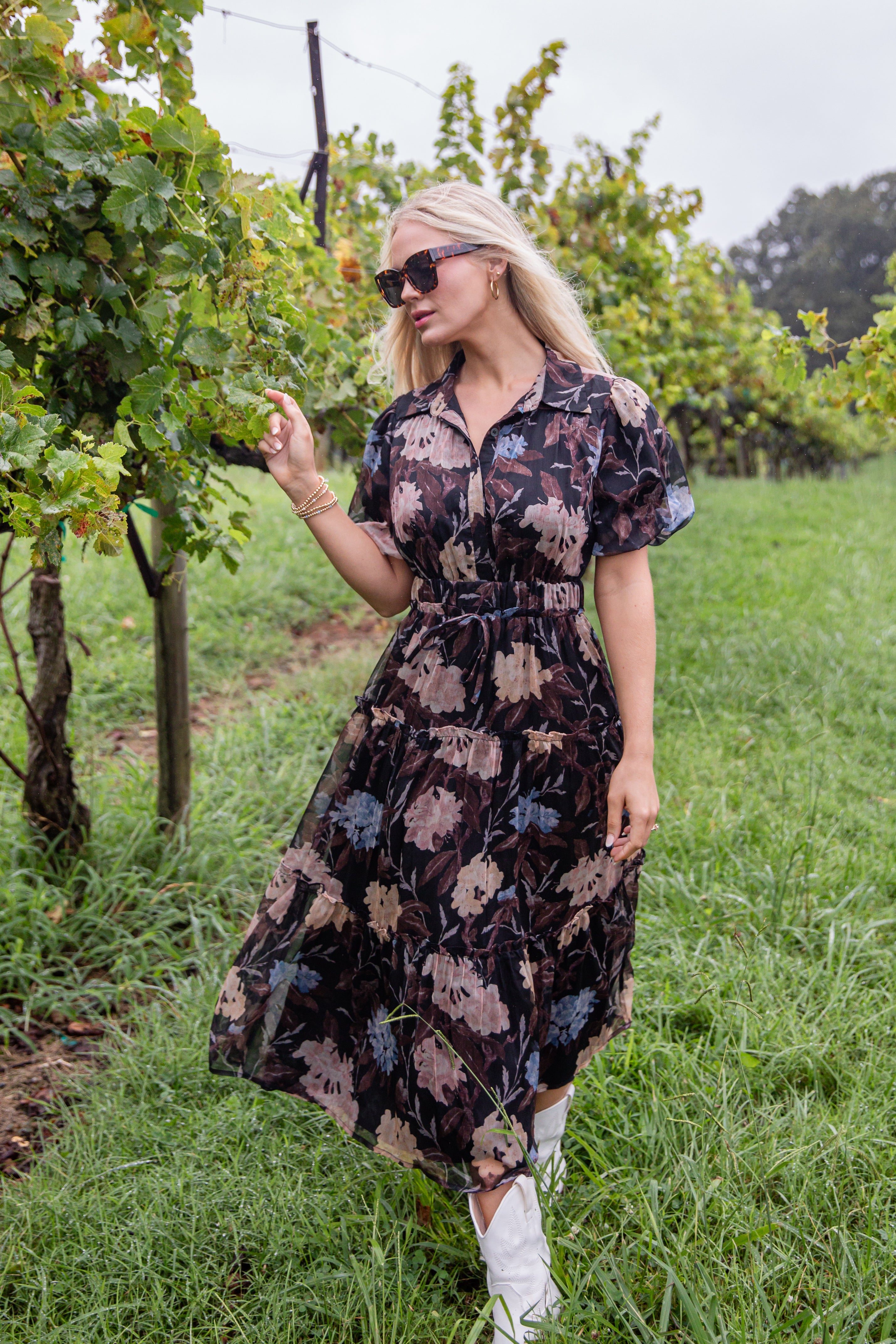 Woman in a floral dress standing in a vineyard