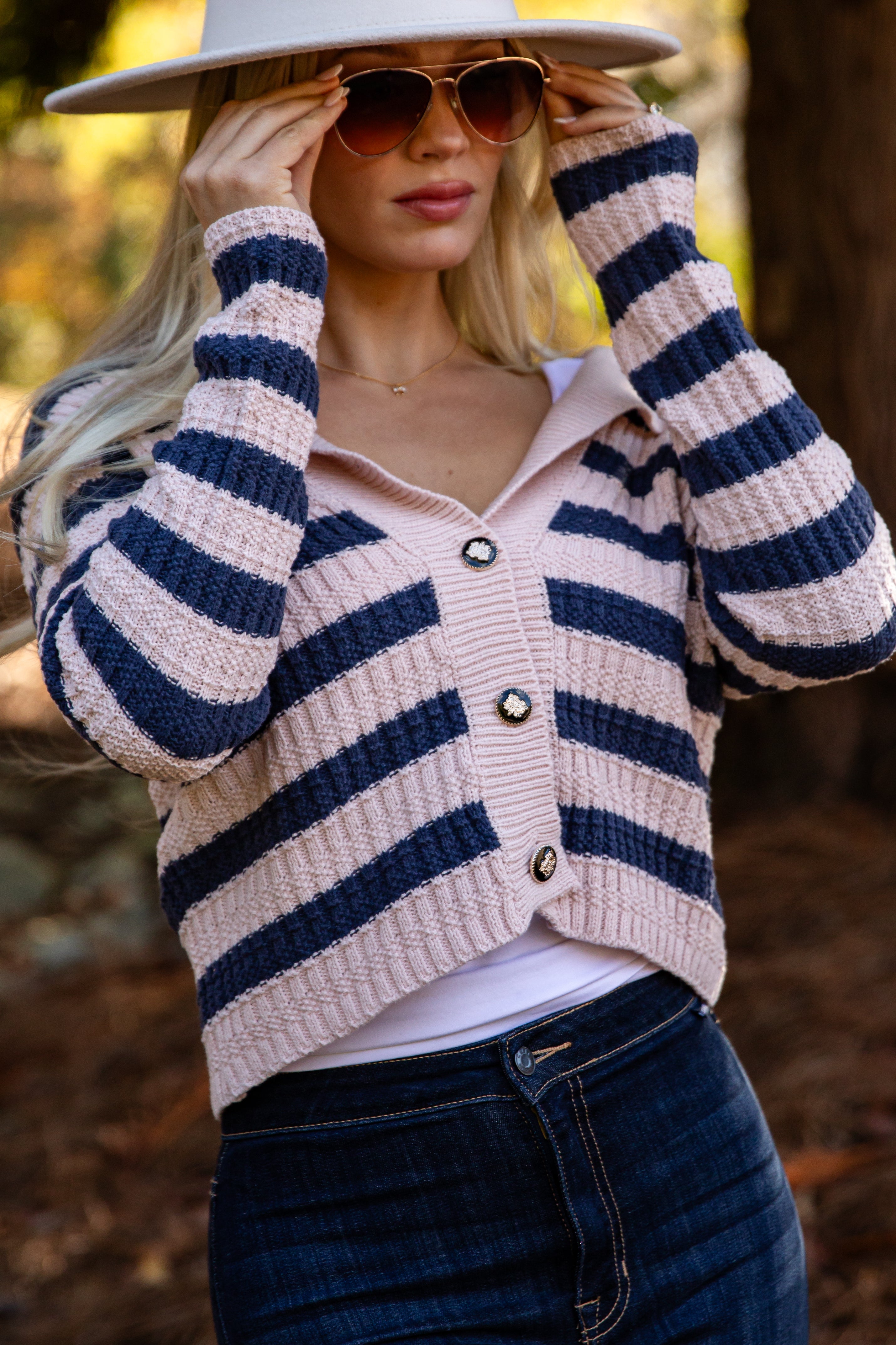 Woman wearing a striped cardigan with a blurred natural background