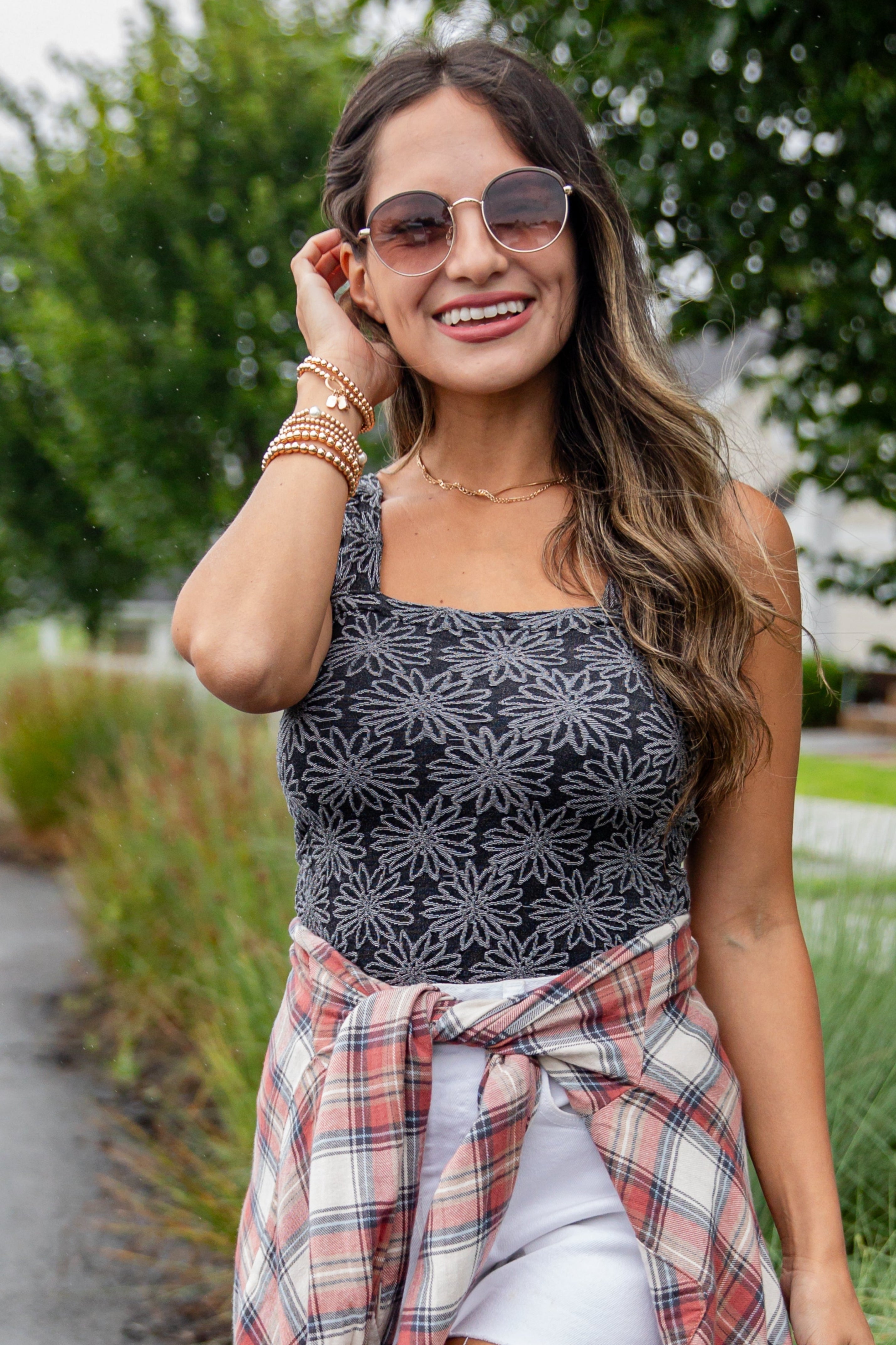 Woman wearing a floral top and plaid skirt outdoors