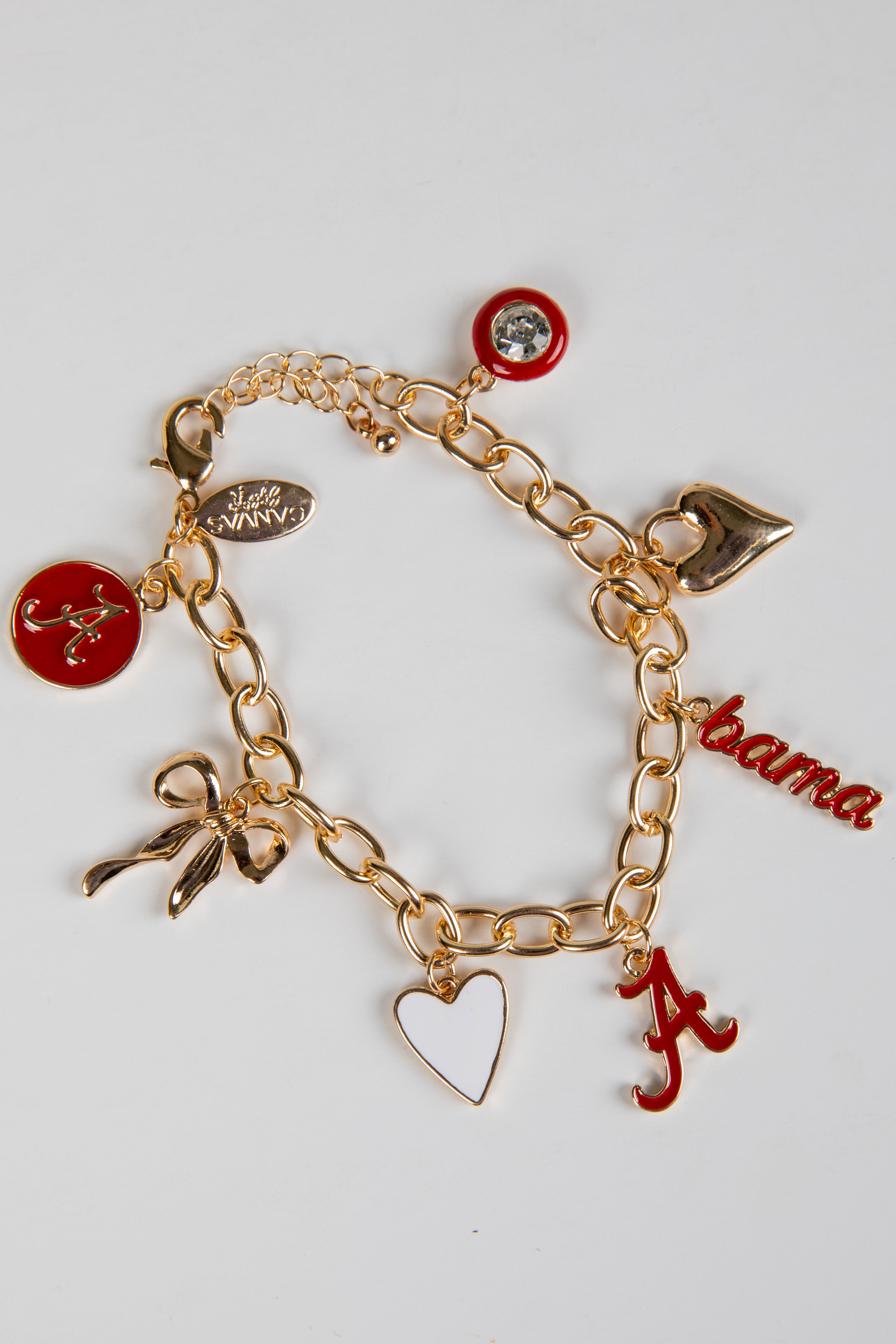 Gold bracelet with various charms including a red &