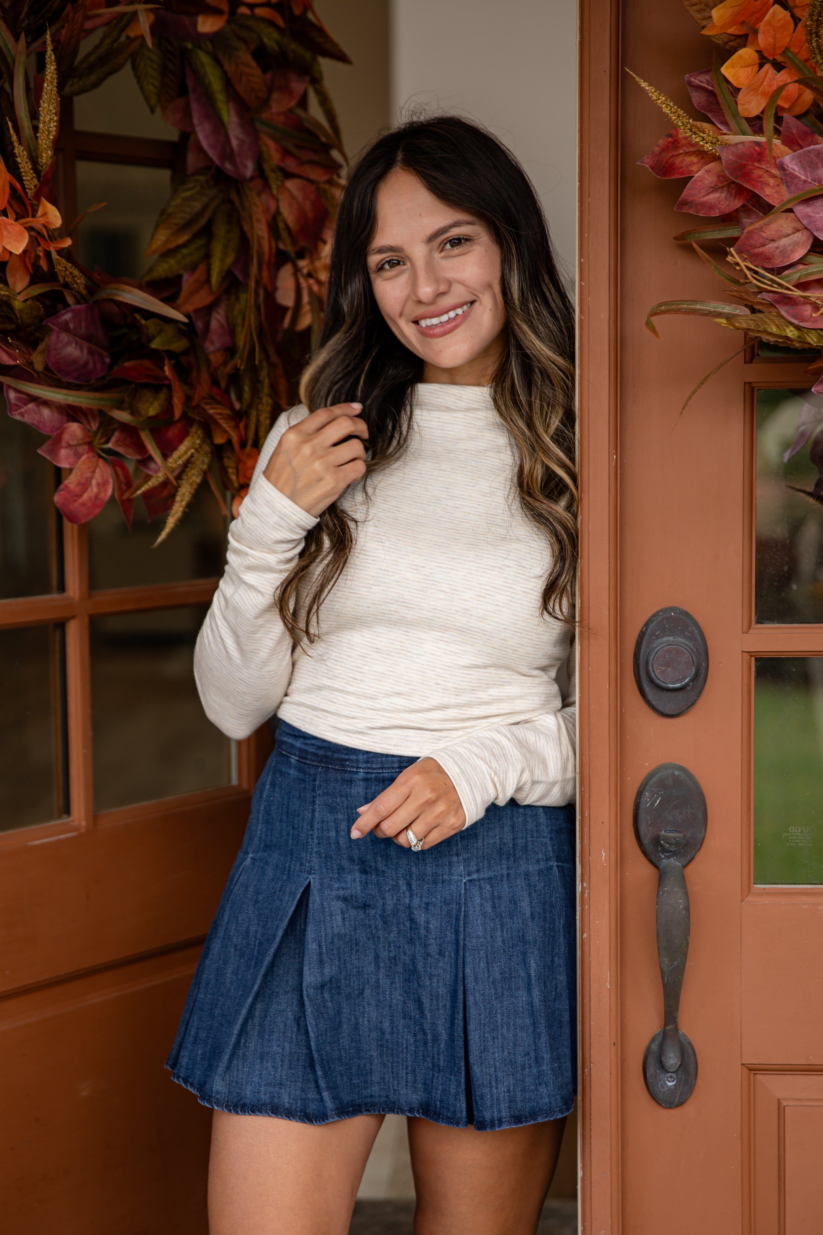 Woman standing in front of a door with autumn decorations