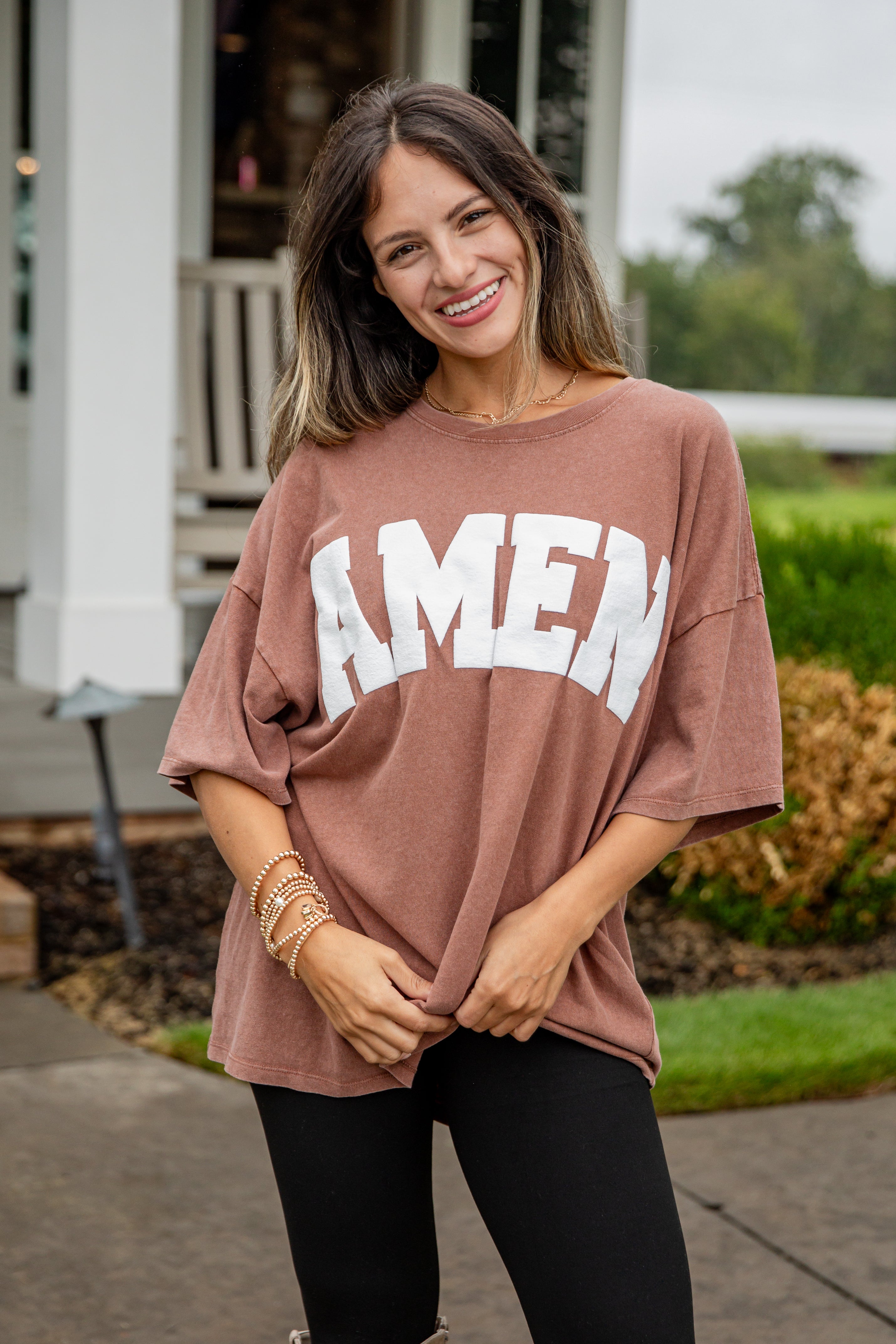 Woman wearing a brown oversized t-shirt with &