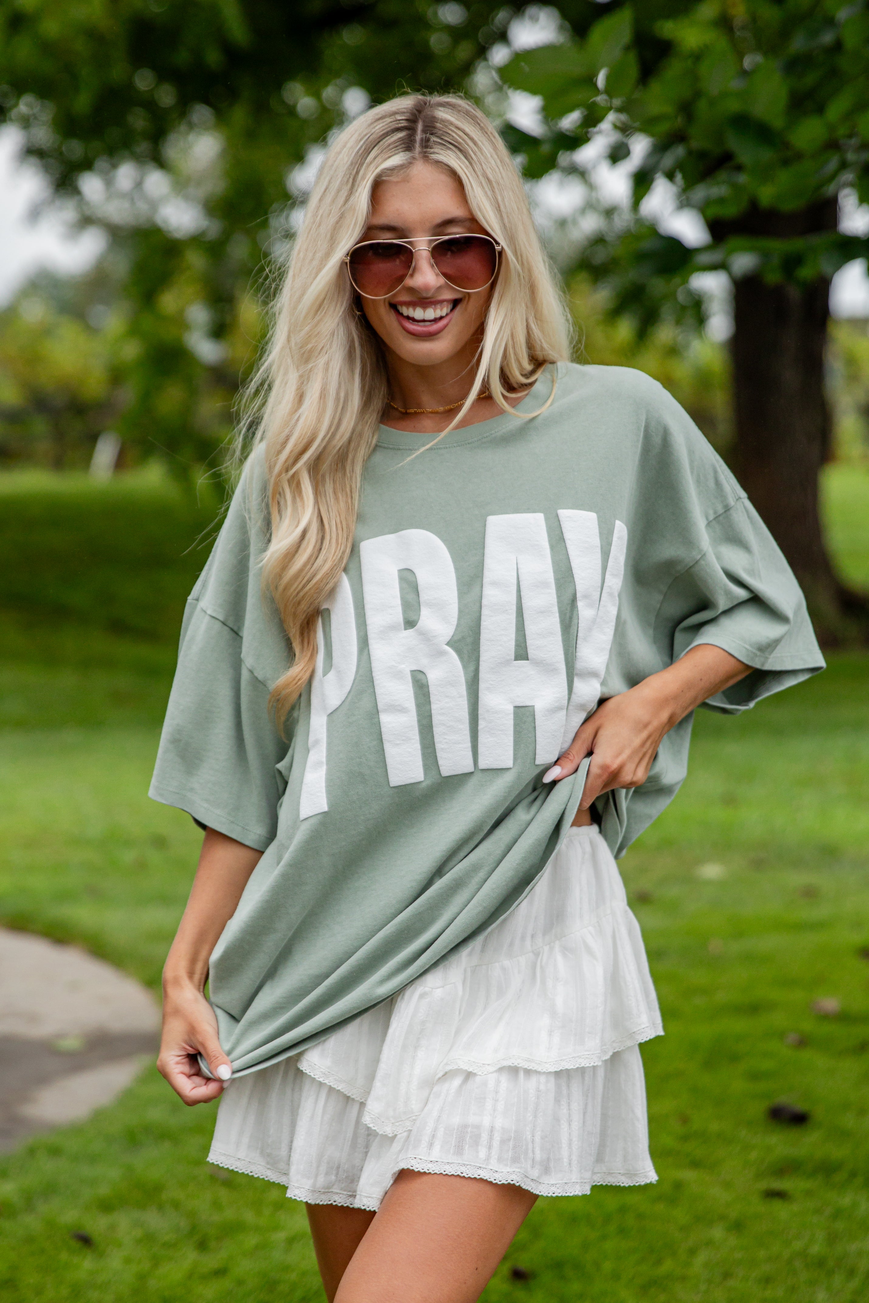 Woman wearing a green oversized t-shirt with &