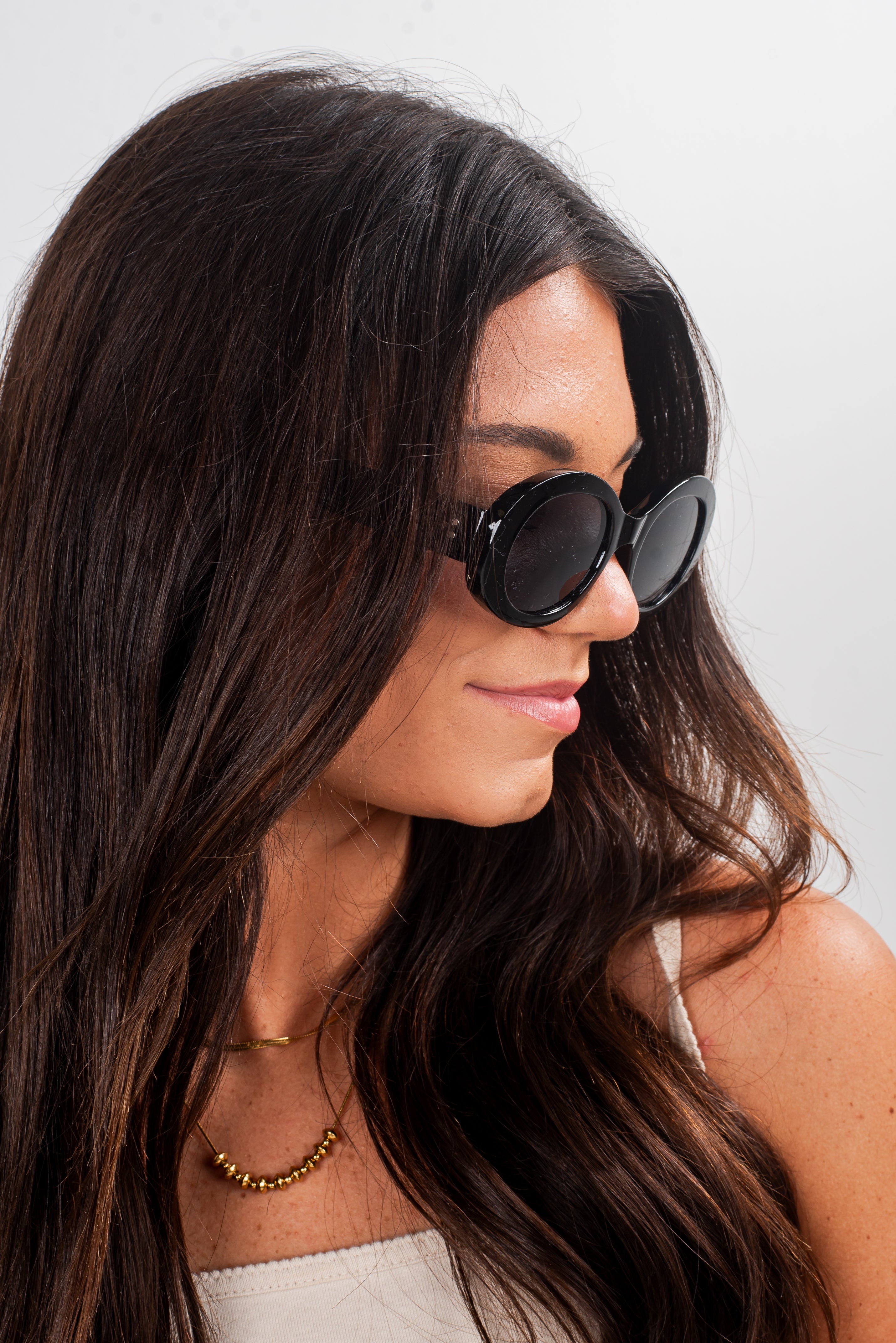 Woman wearing black sunglasses with a plain background