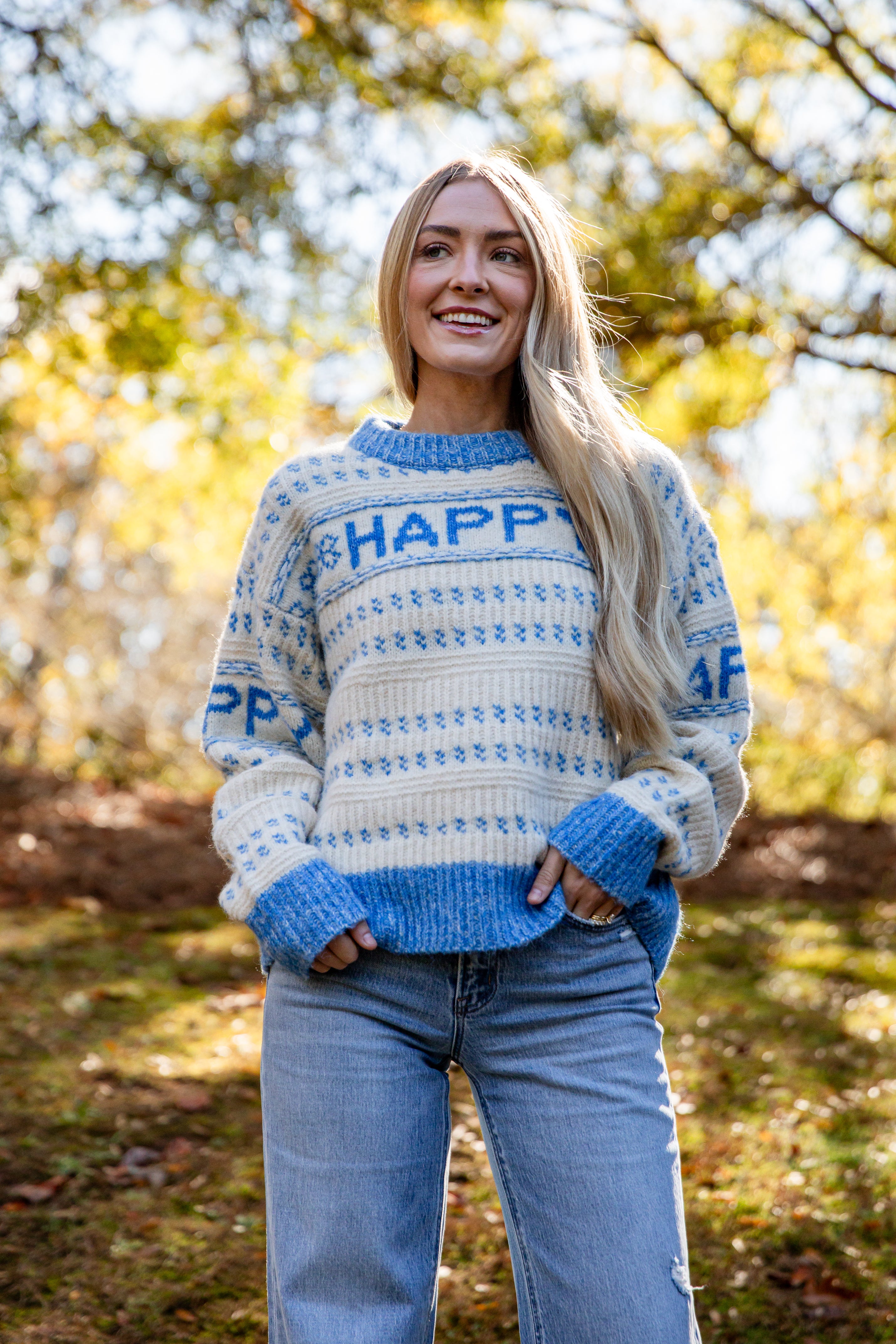 Woman wearing a blue and white sweater with &