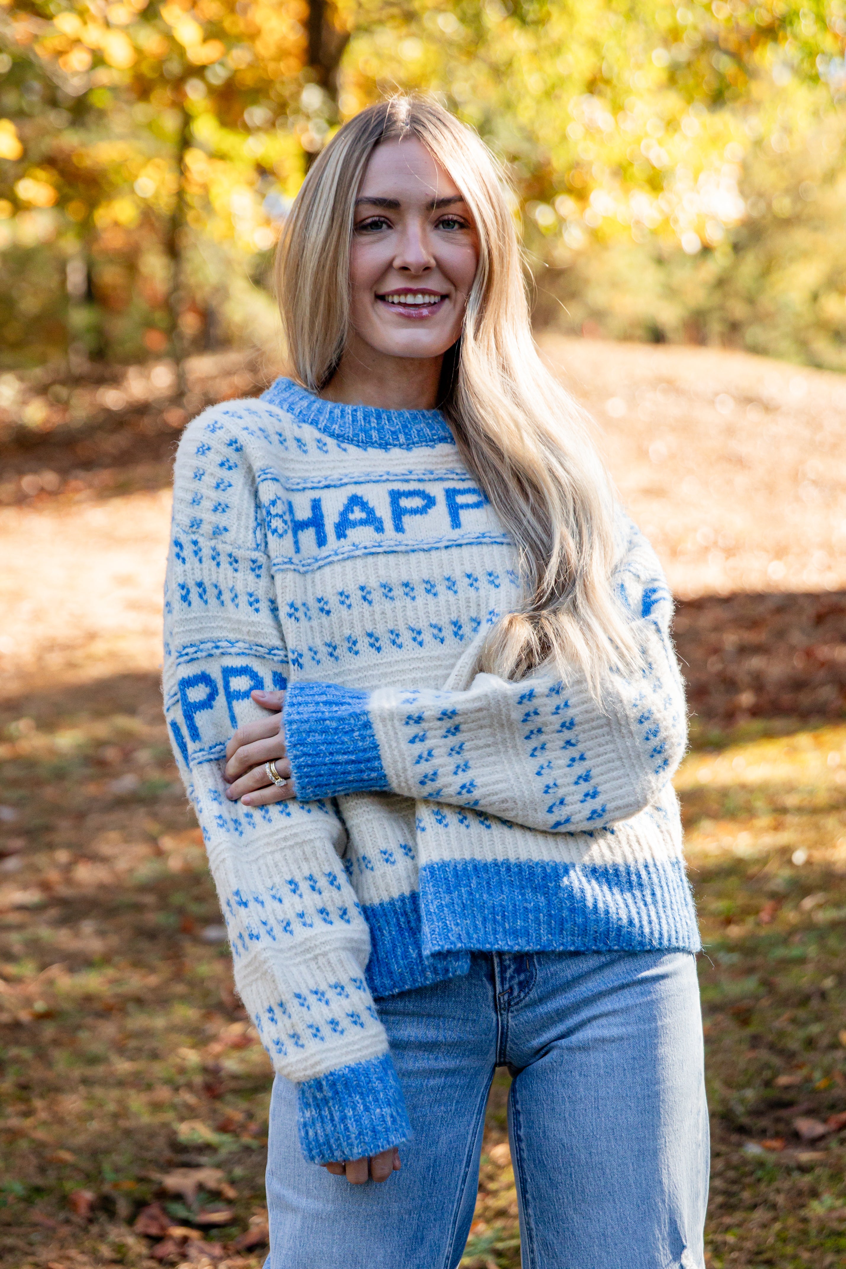 Woman wearing a blue and white patterned sweater with &