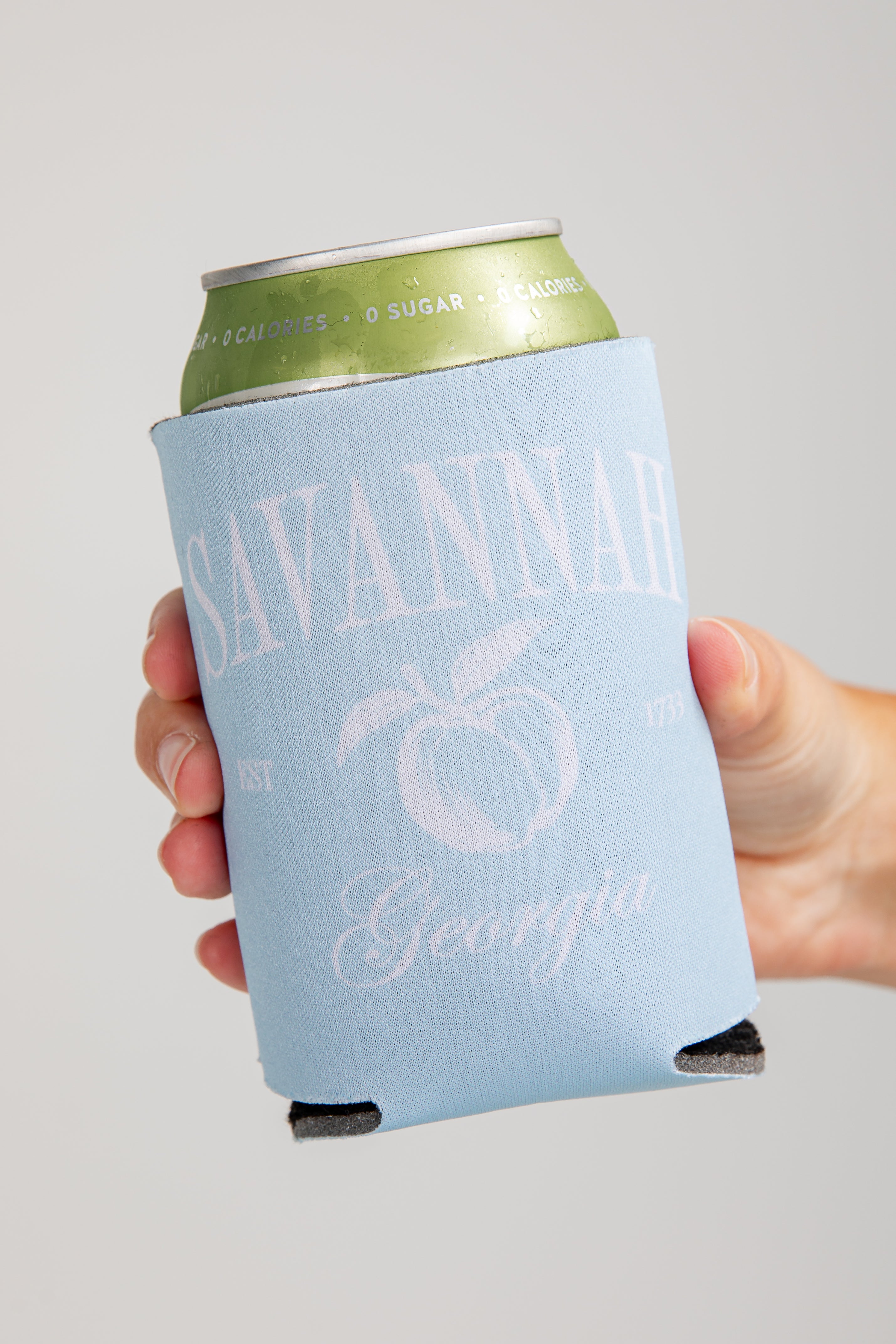 Hand holding a can with a &