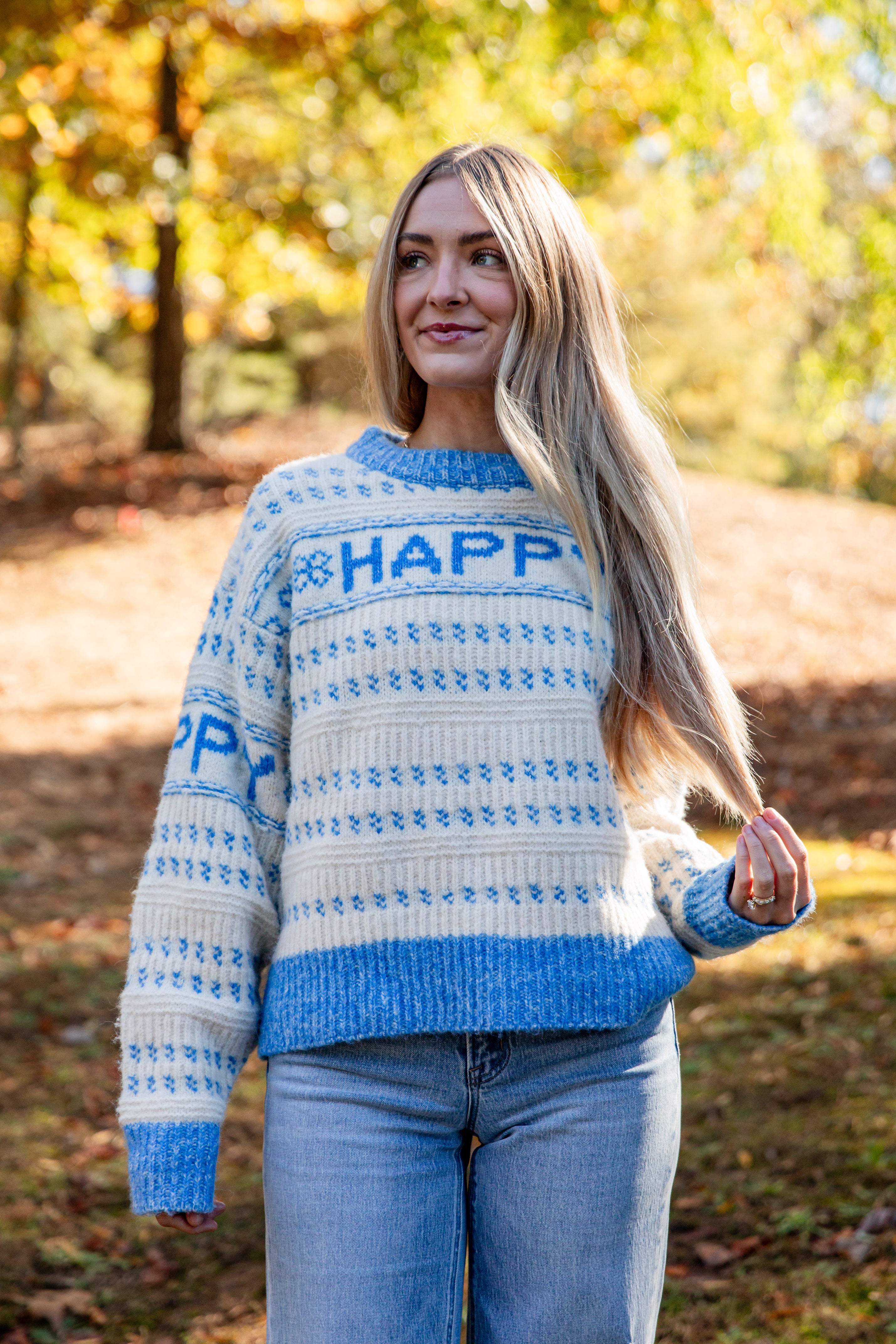 Woman wearing a blue and white patterned sweater with &