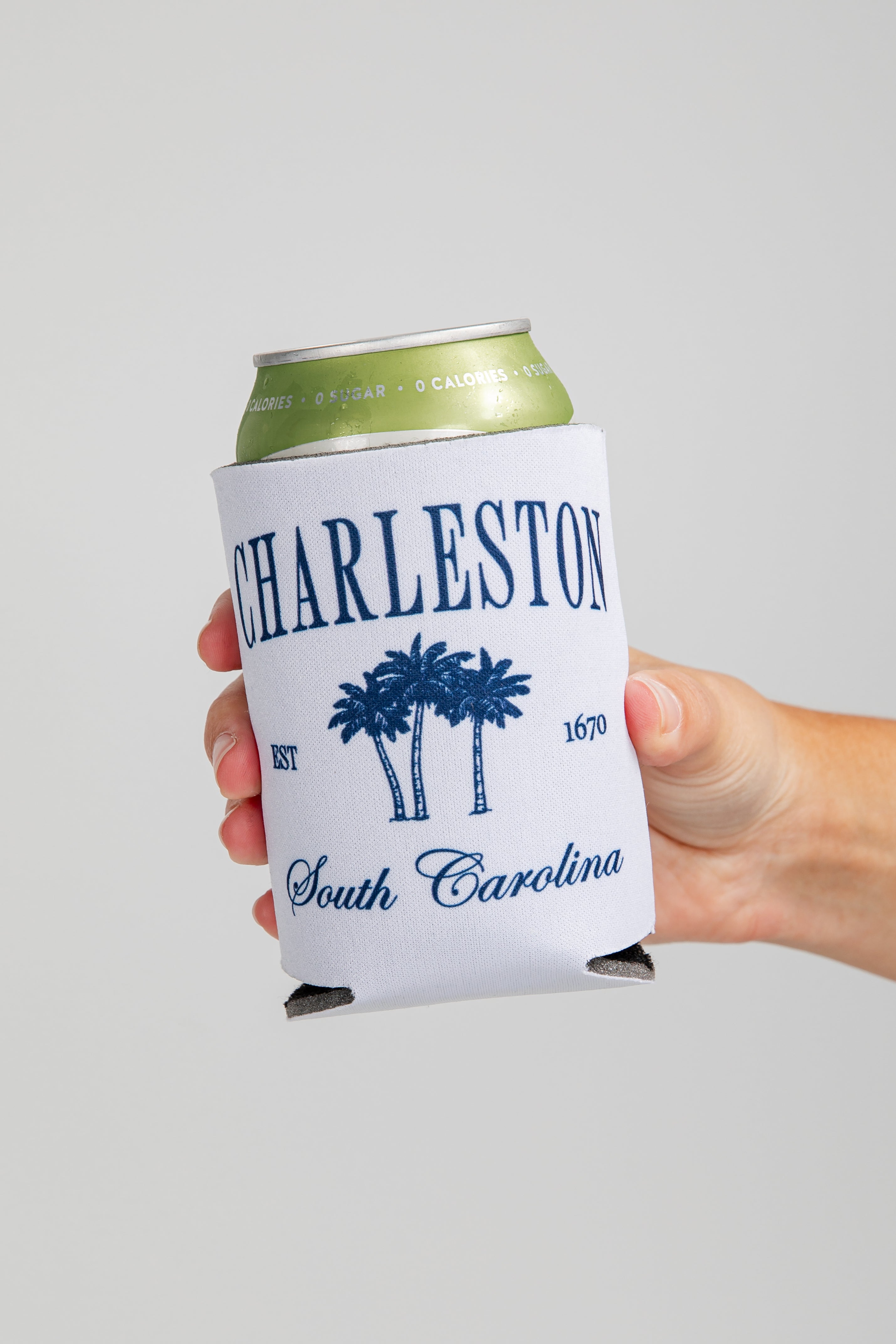 Hand holding a can cooler with &