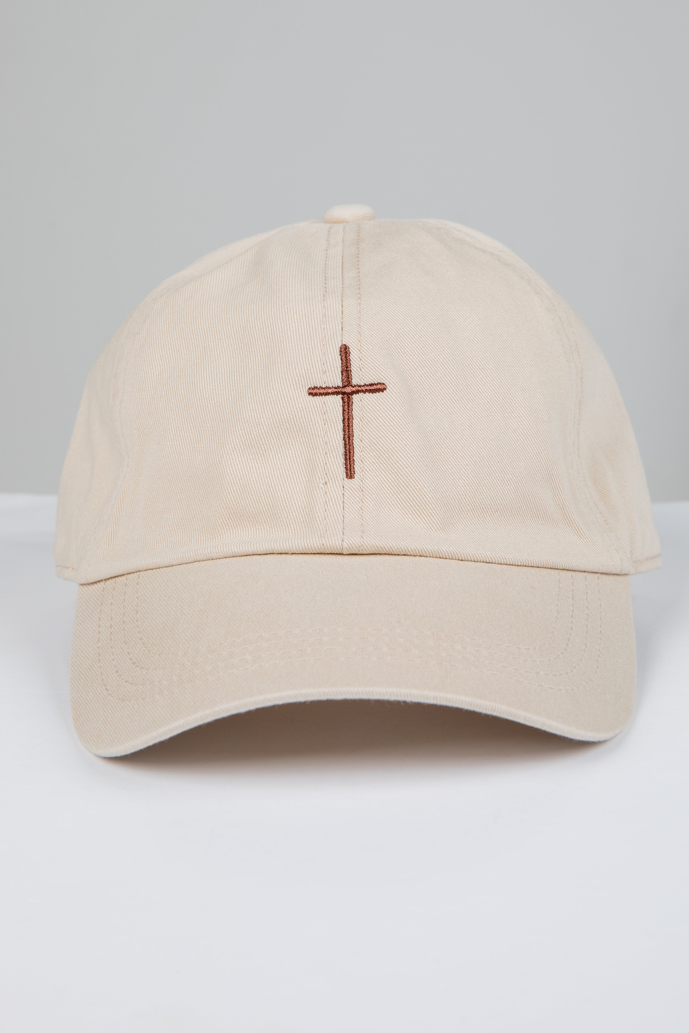 Beige cap with a brown cross on a white background
