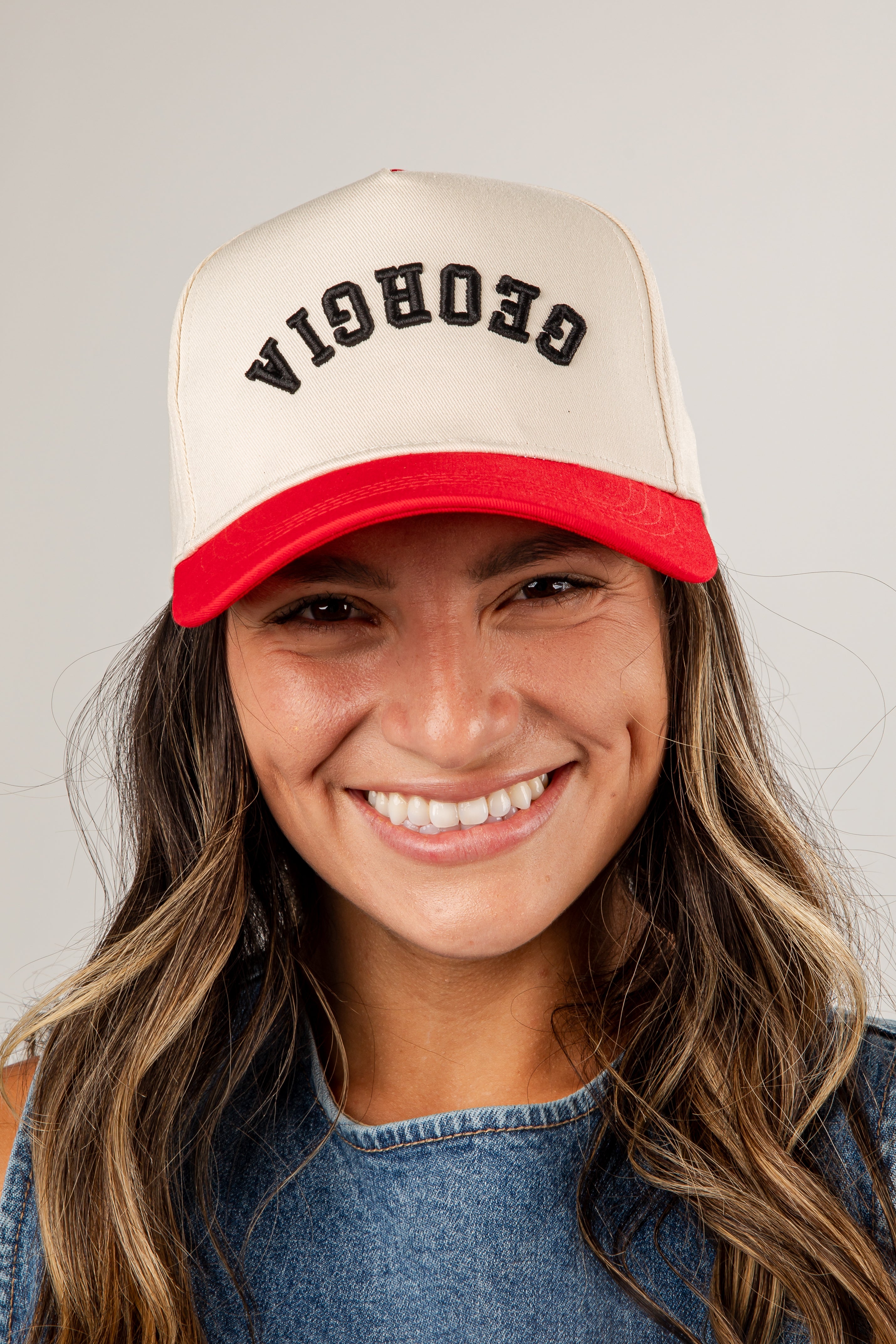 Person wearing a beige and red cap with &