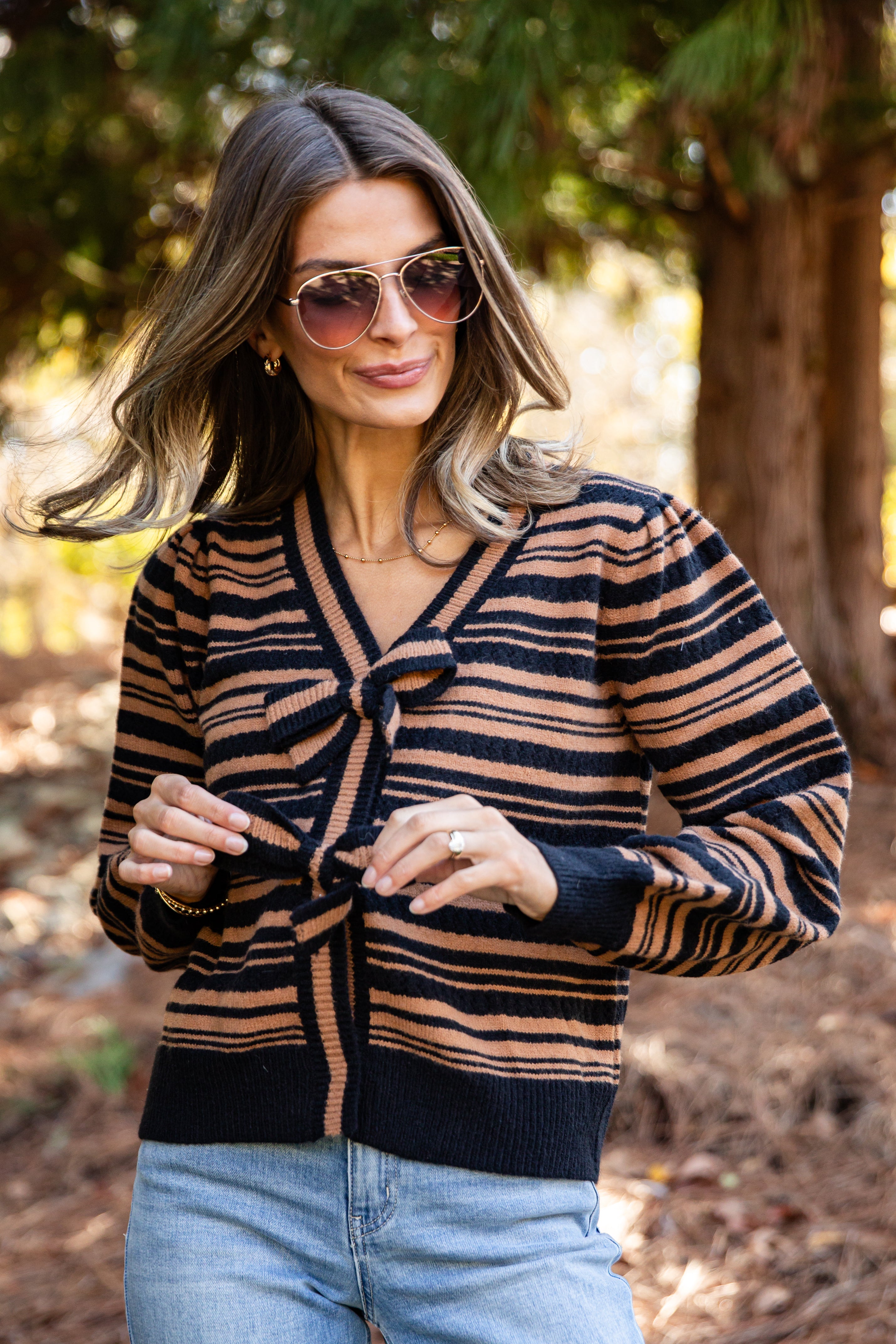 Woman wearing a striped sweater and sunglasses outdoors