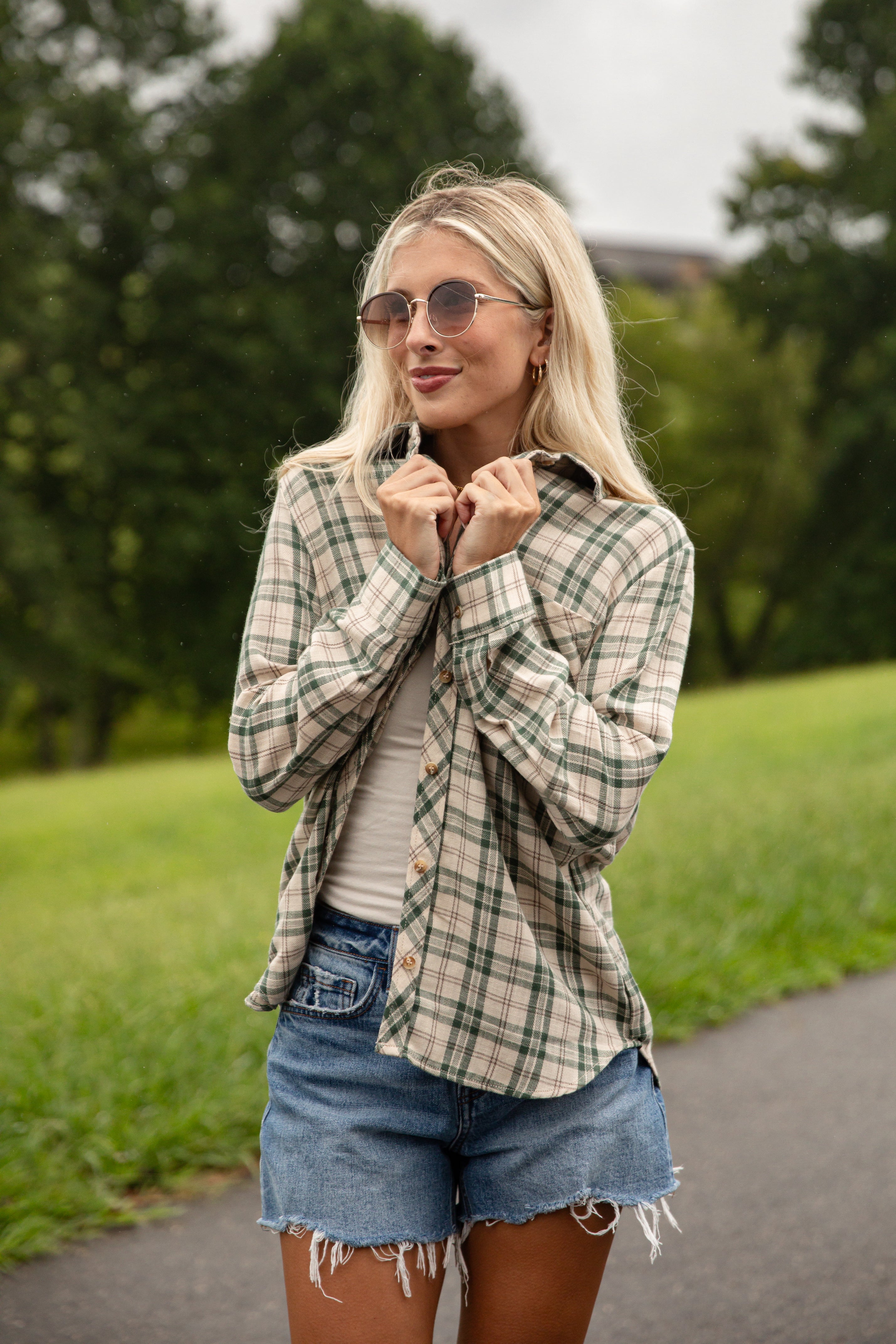 Woman wearing a plaid shirt and denim shorts outdoors