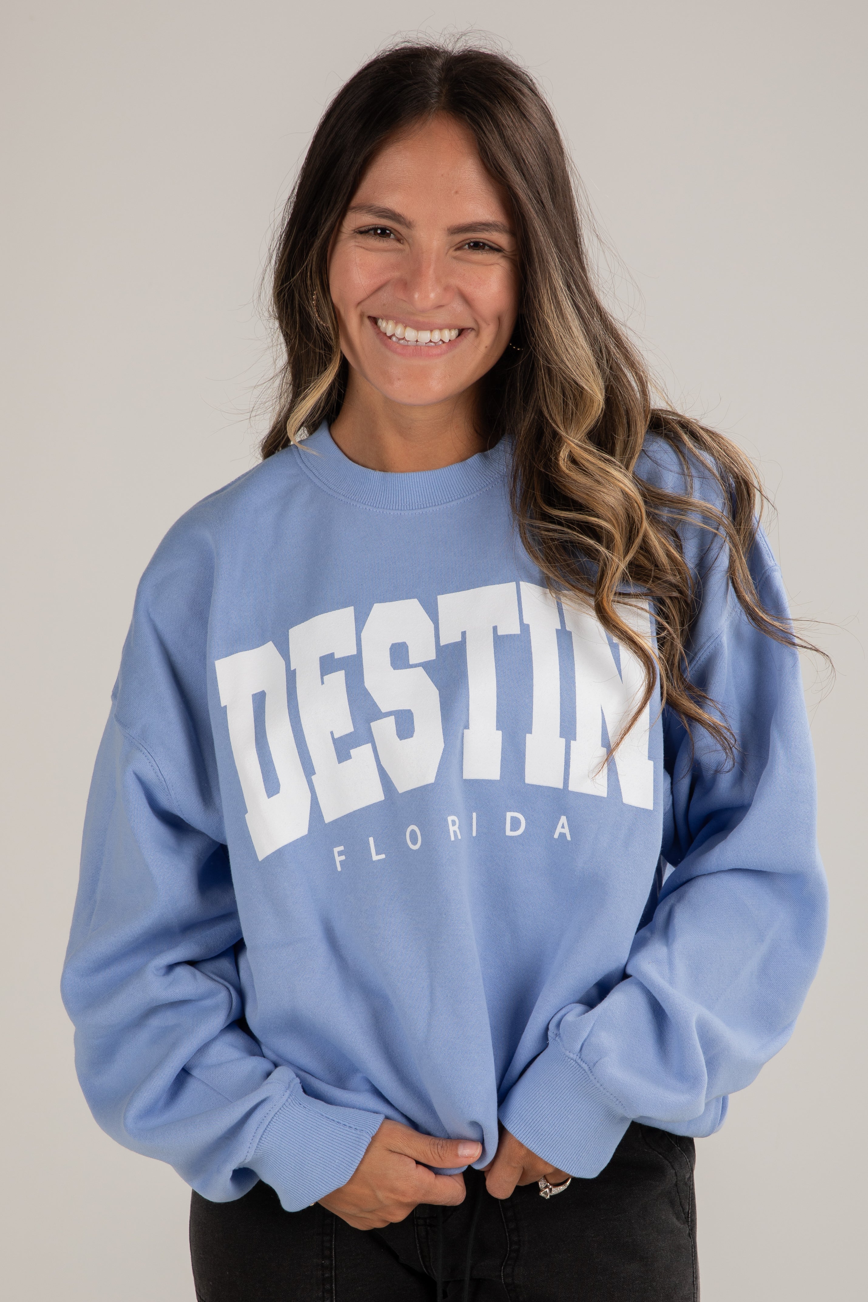 Woman wearing a blue sweatshirt with &