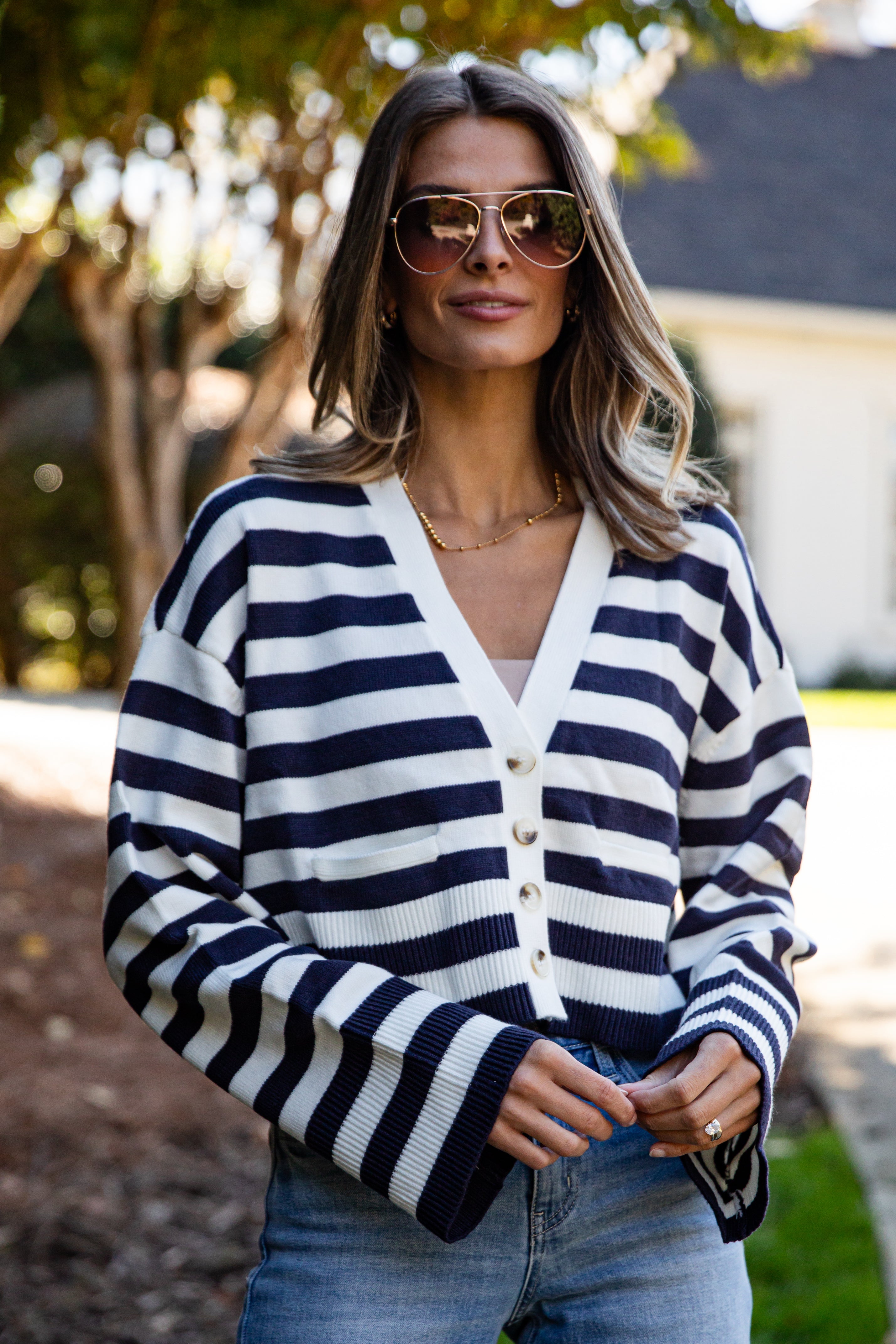 Woman wearing a navy and white striped cardigan outdoors