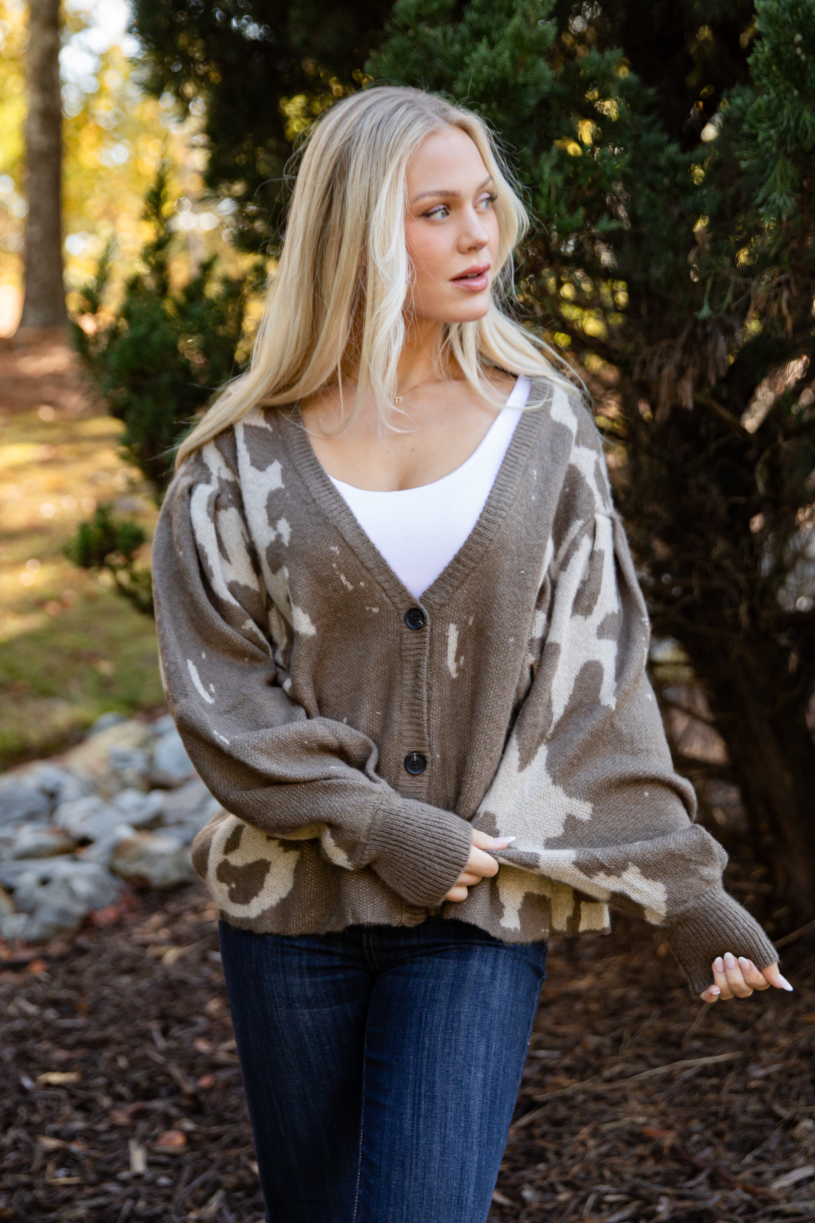 Woman wearing a camouflage-patterned cardigan outdoors