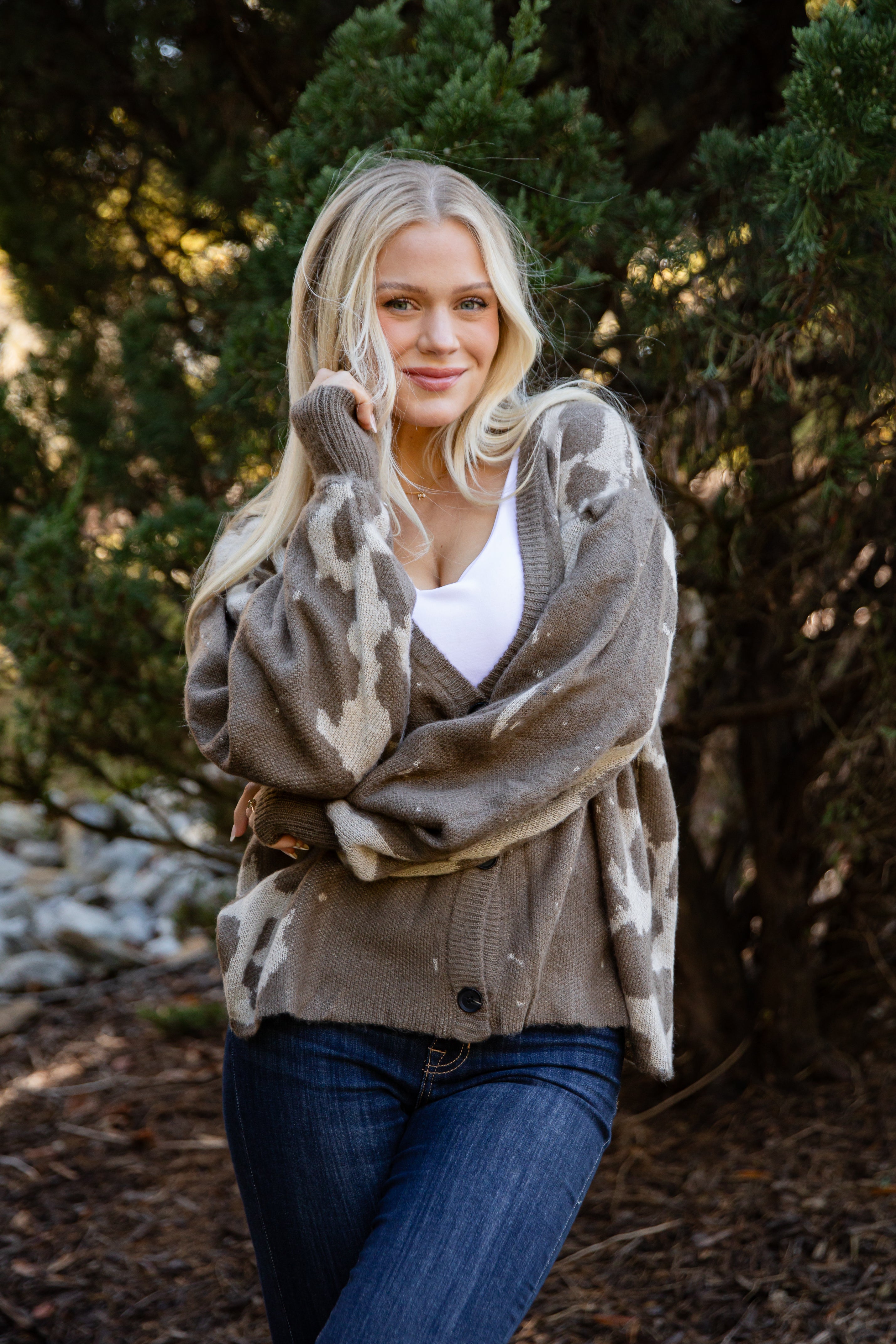 Woman wearing a patterned cardigan in a natural setting