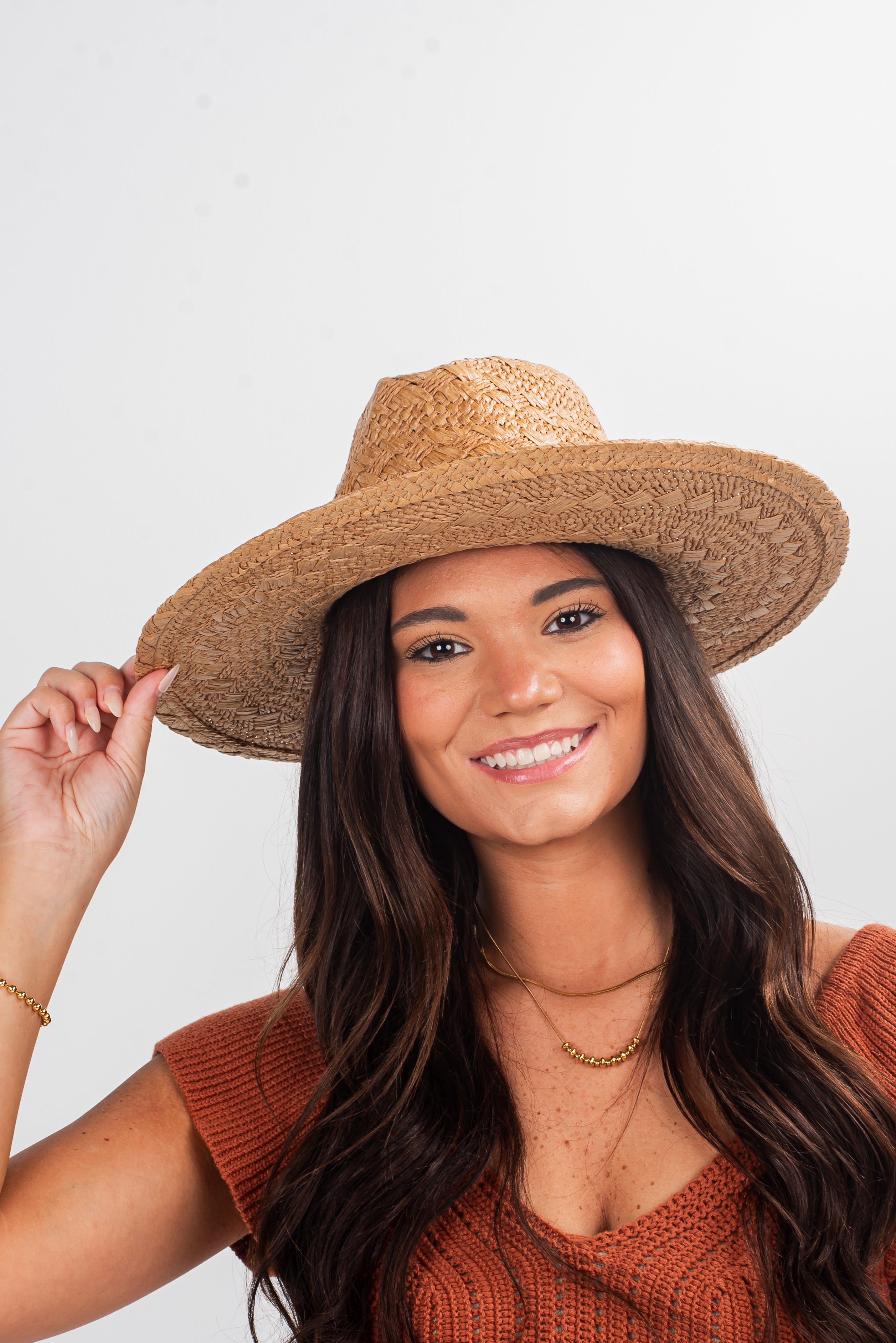 Woman wearing a straw hat against a plain background