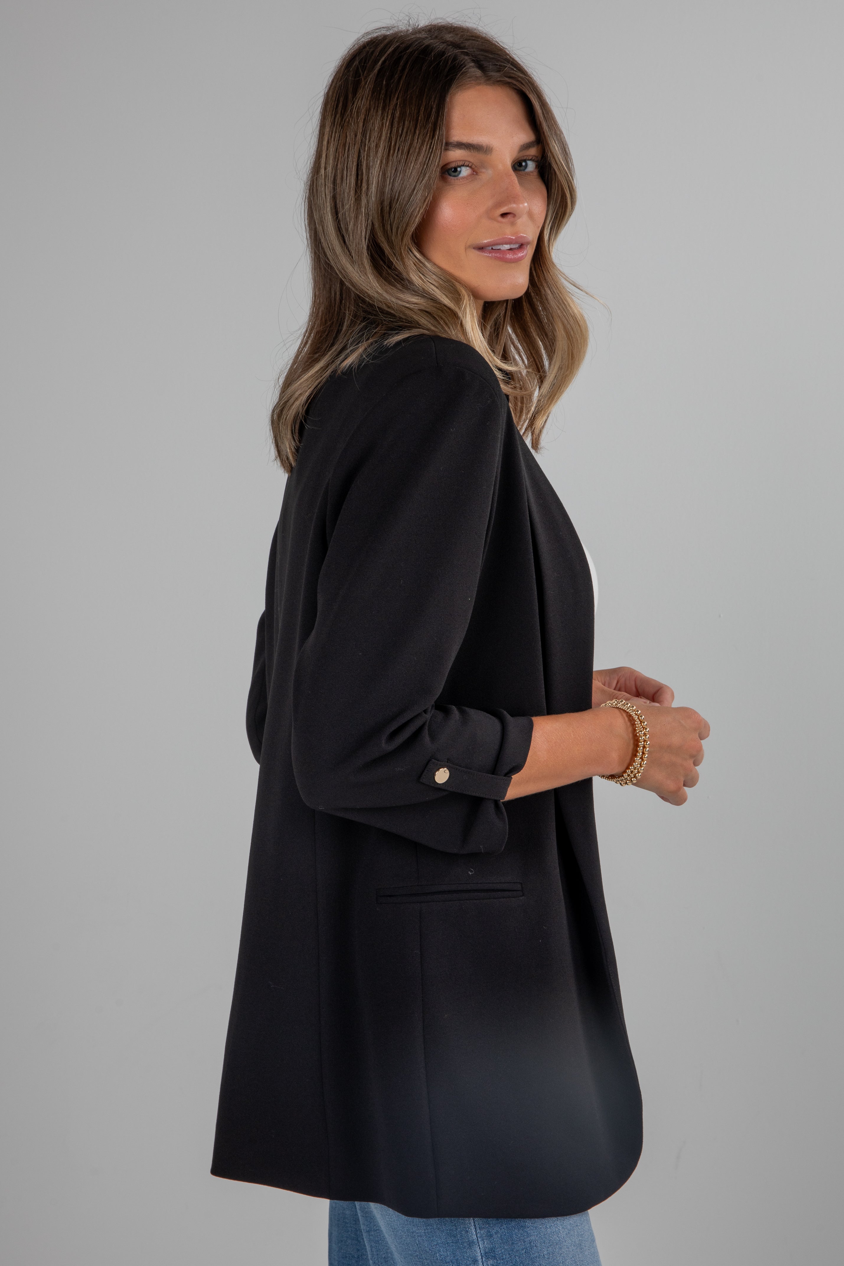 Woman wearing a black blazer against a gray background