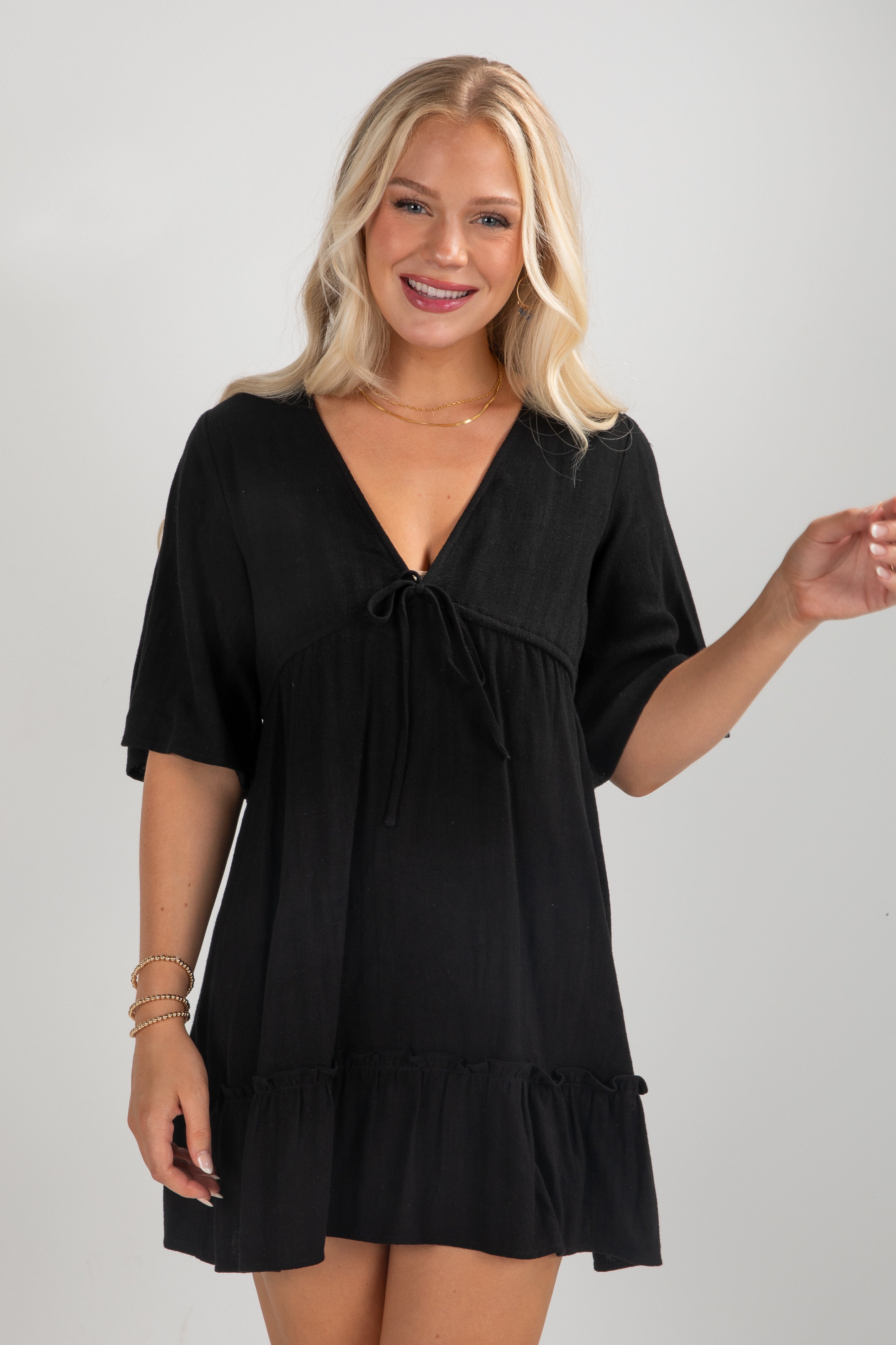 Woman wearing a black dress against a plain background