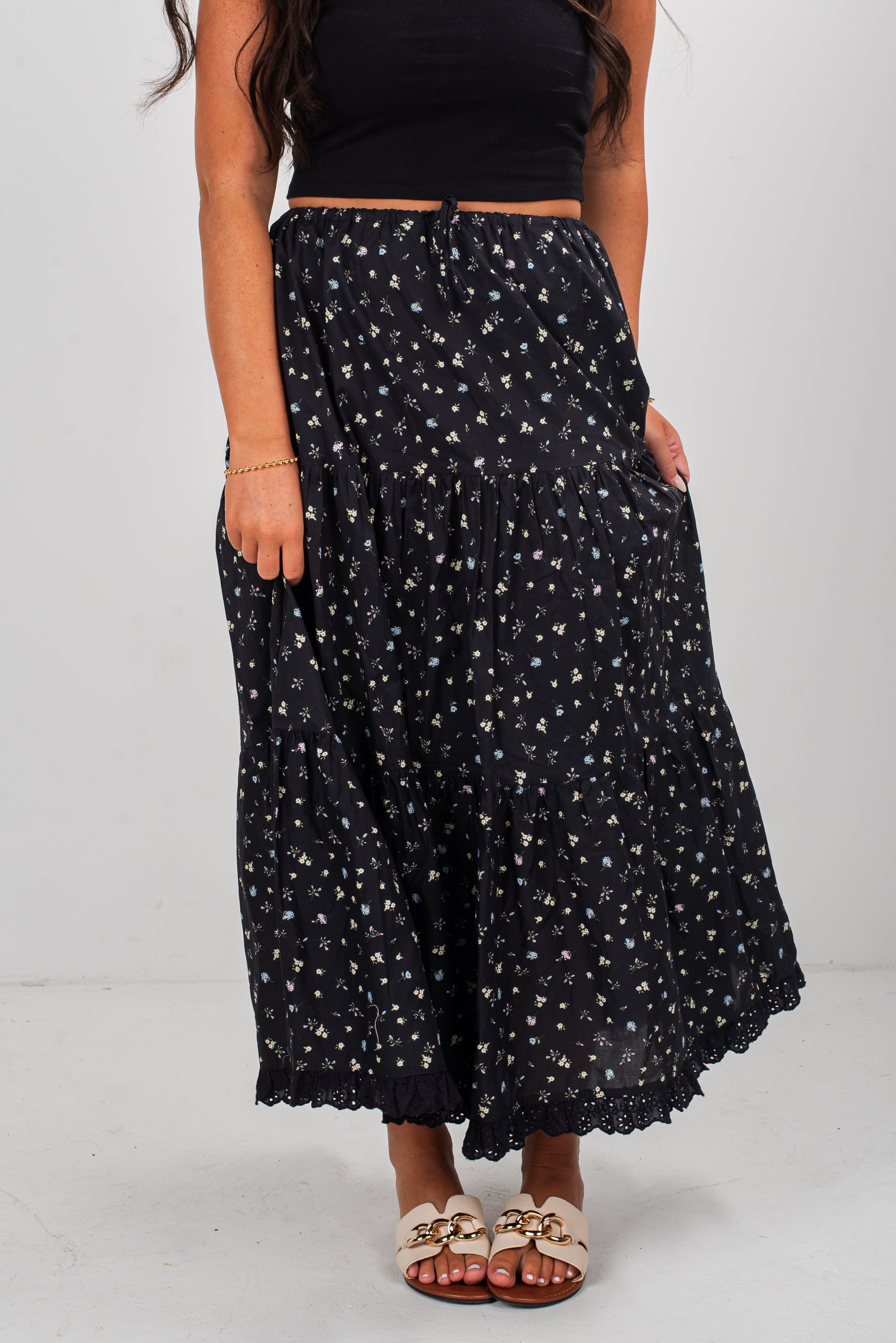 Woman wearing a black floral skirt on a white background