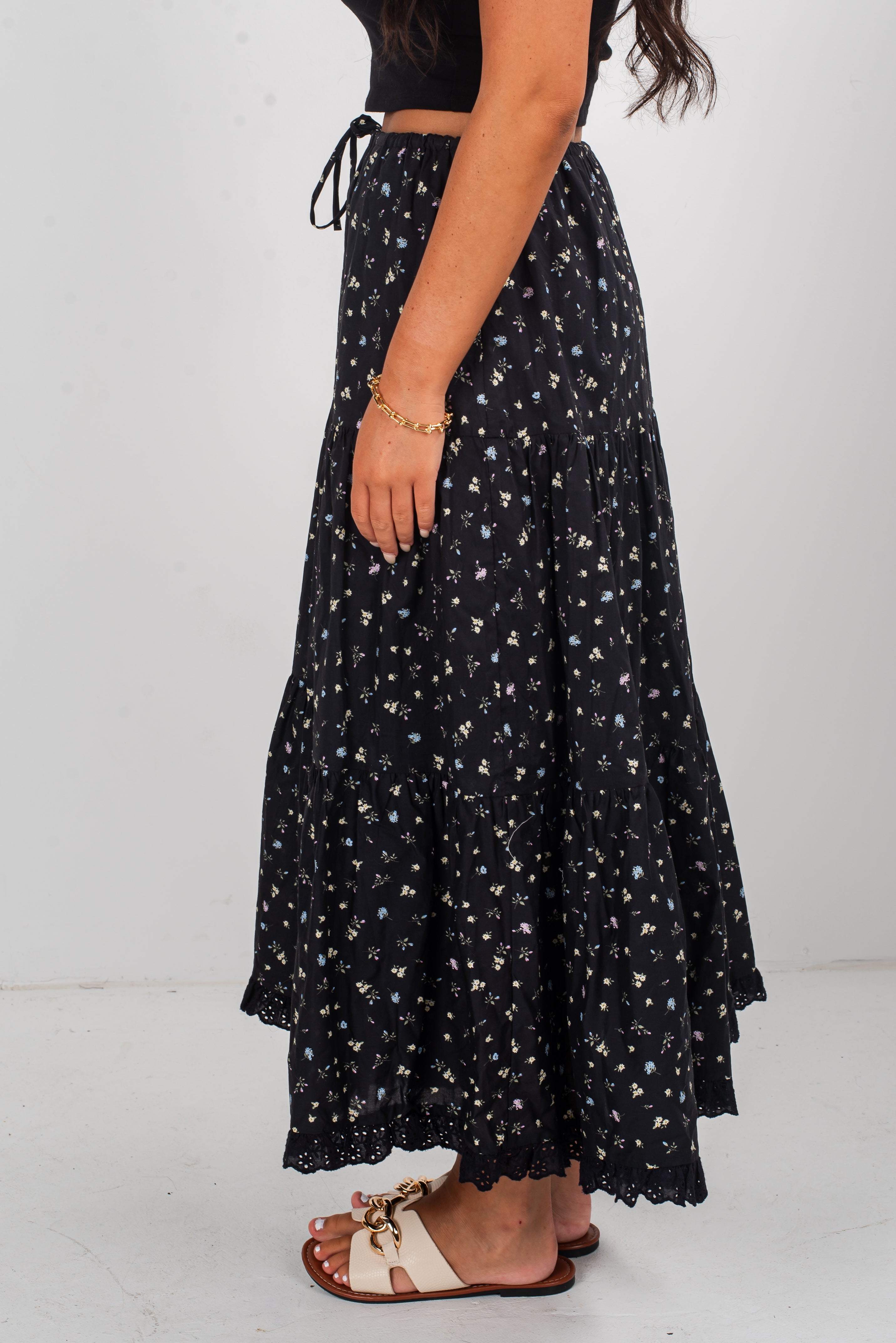 Person wearing a black floral skirt on a white background