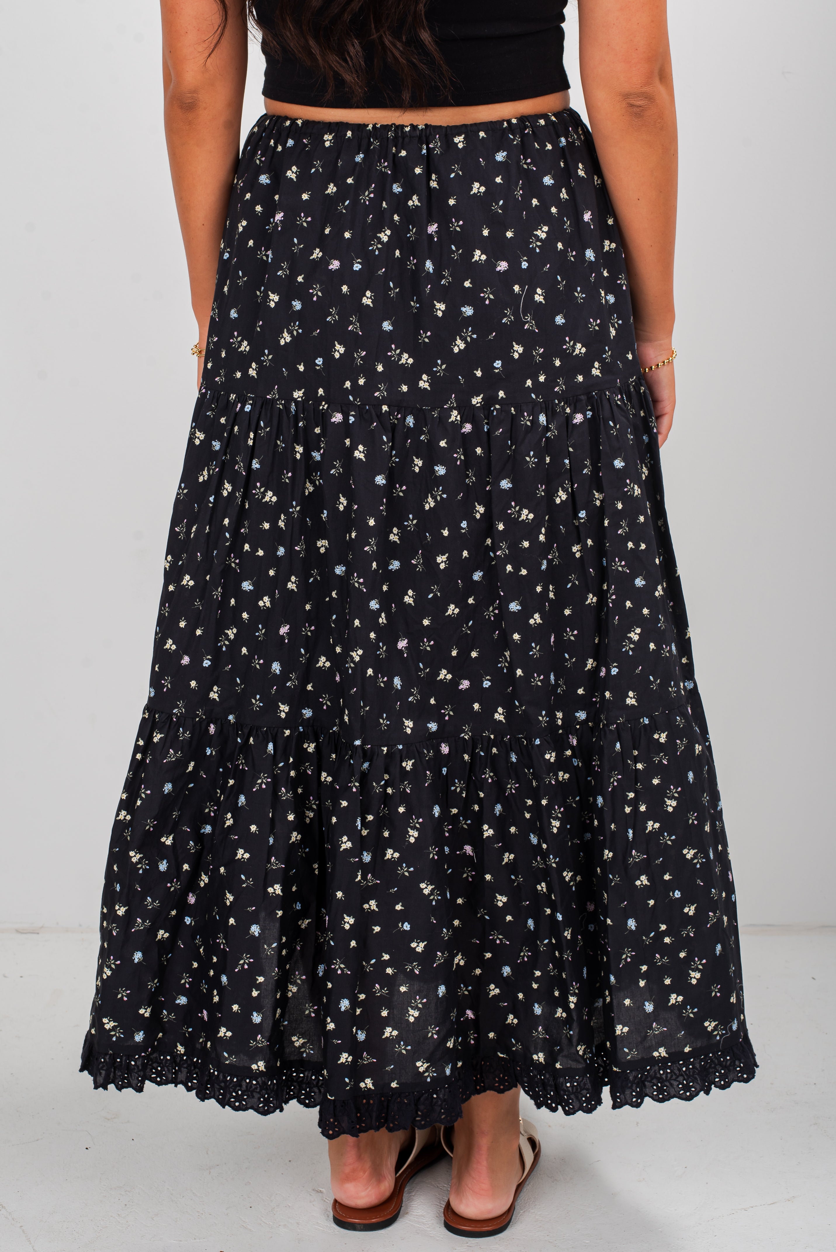 Black floral patterned skirt worn by a person on a white background