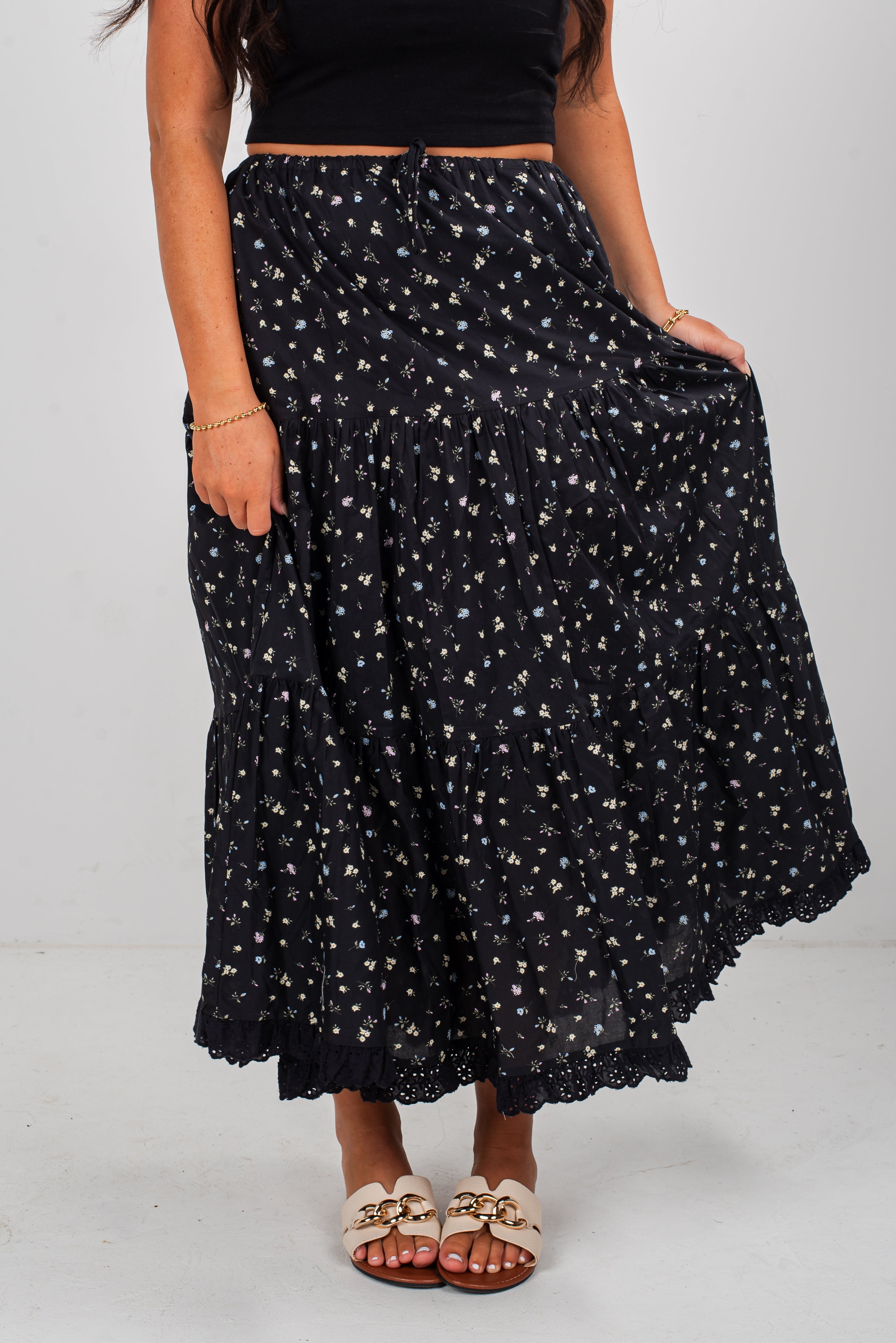 Person wearing a black floral skirt on a white background