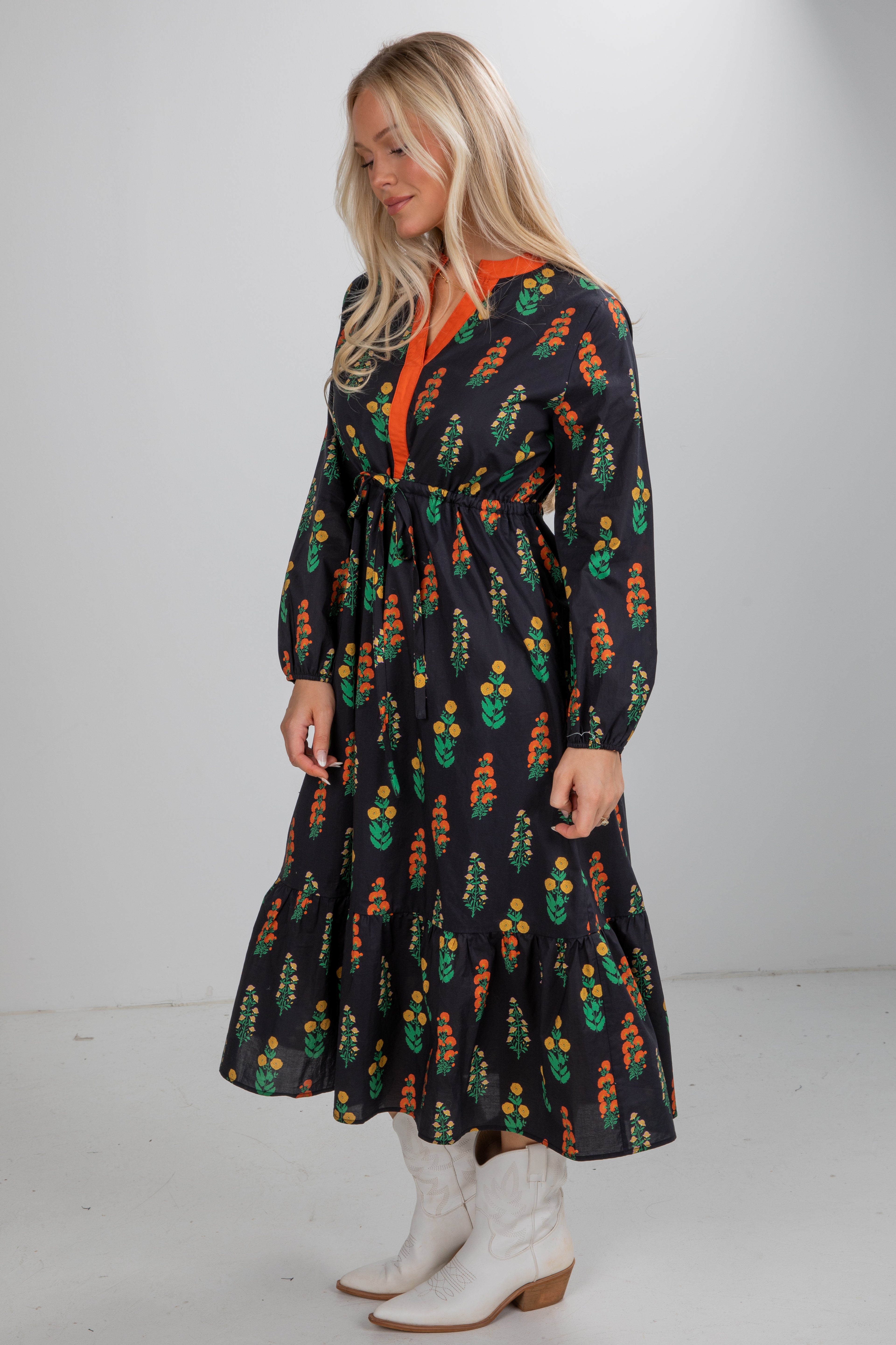 Woman wearing a long-sleeve dress with a floral pattern on a plain background