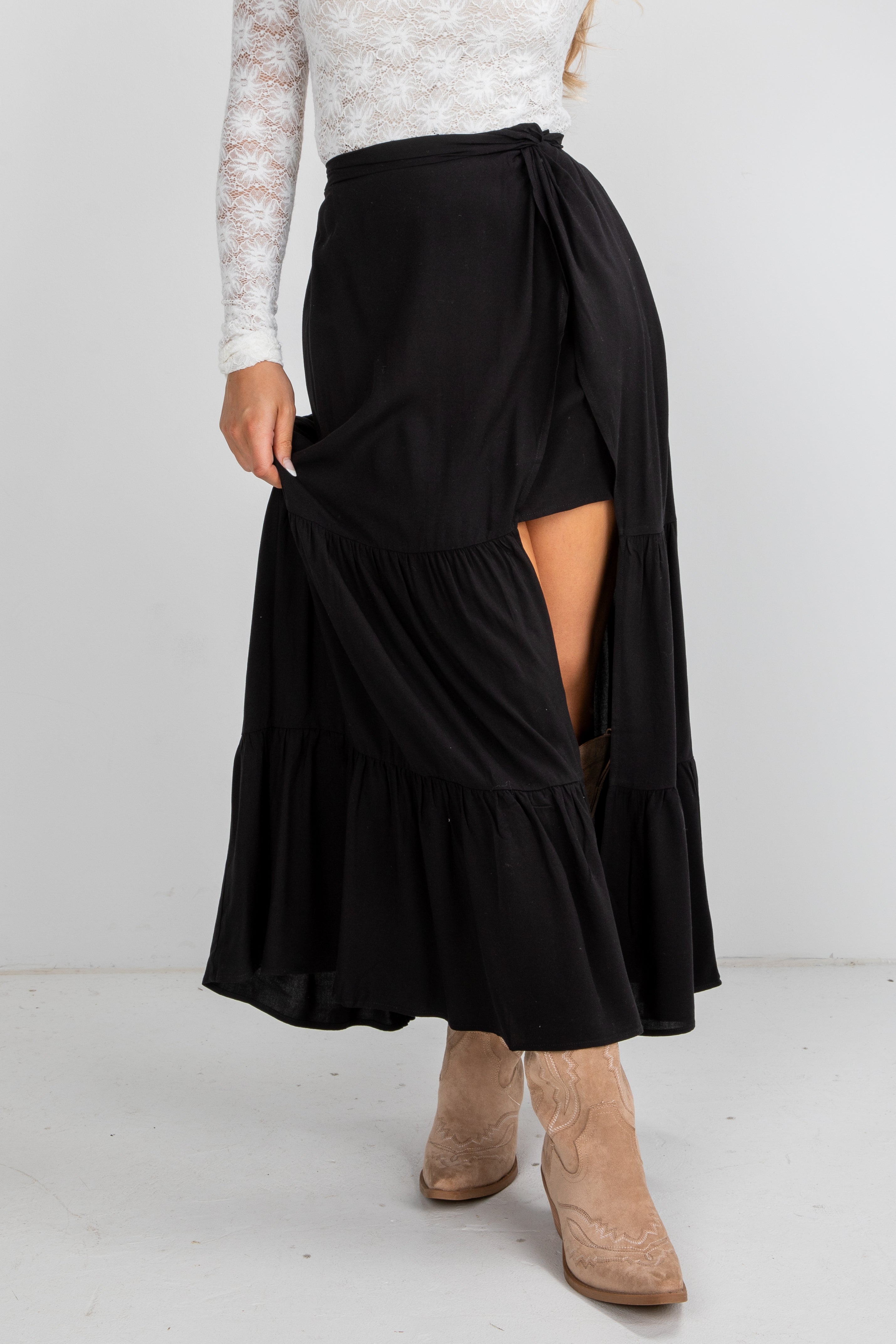 Black skirt with a slit worn by a person on a white background