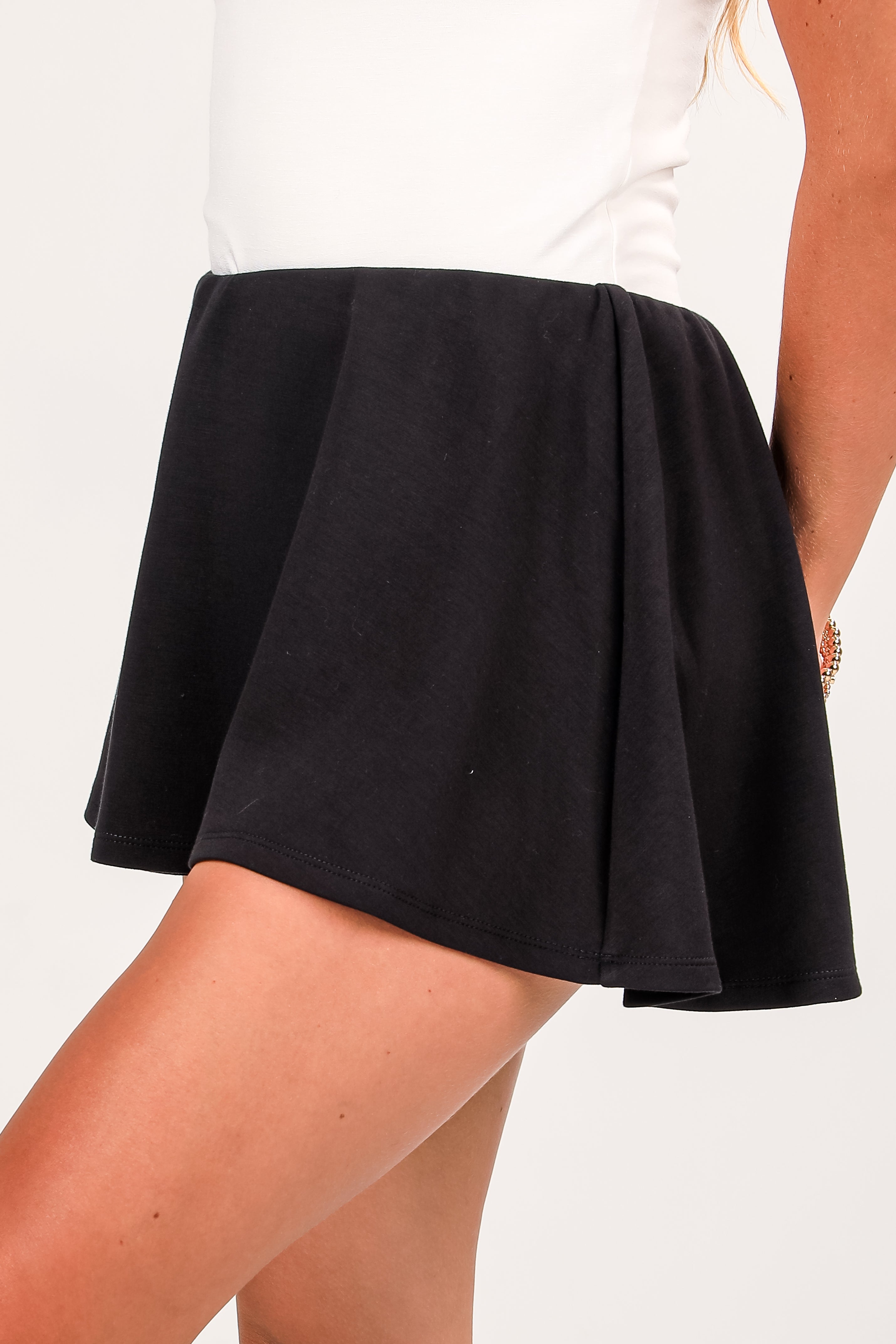 Black skirt worn by a person on a white background