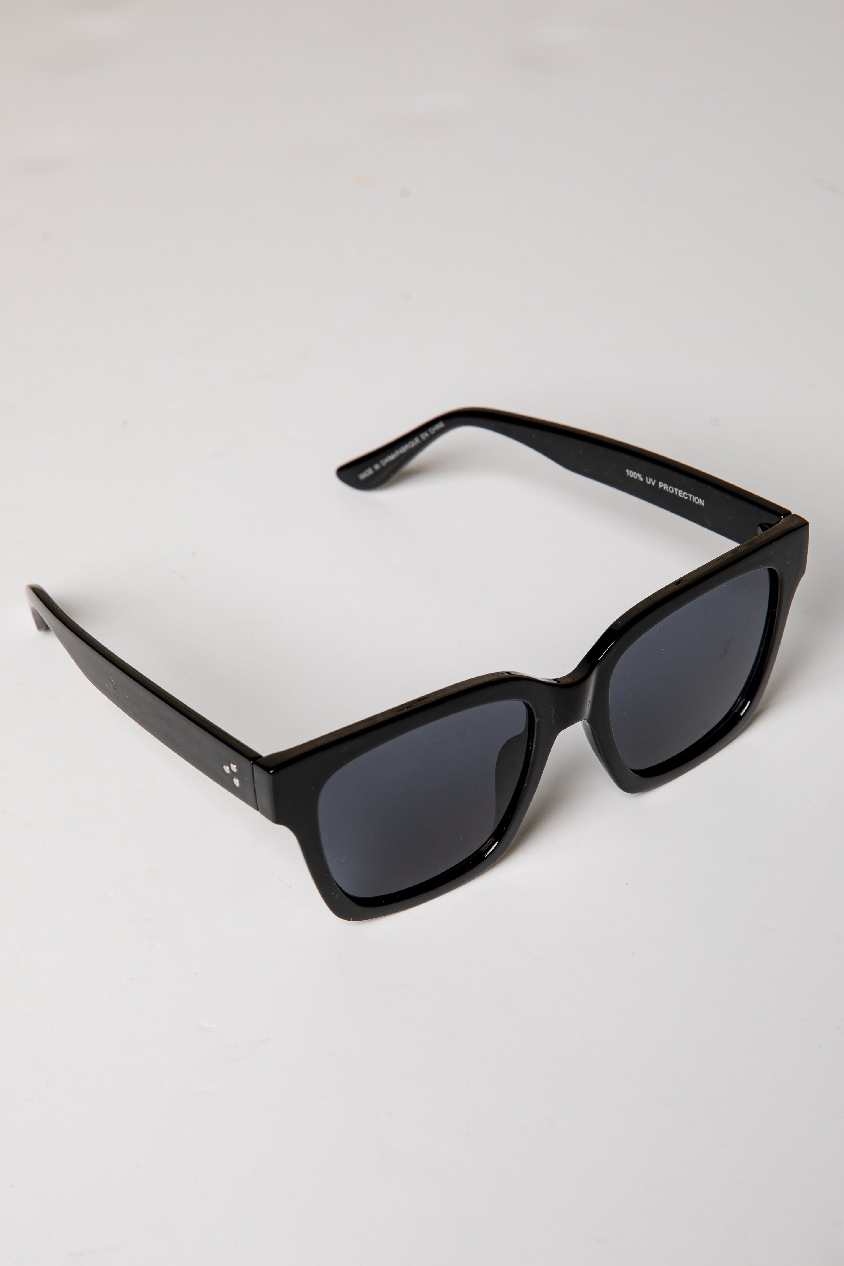 Black sunglasses with dark lenses on a white background