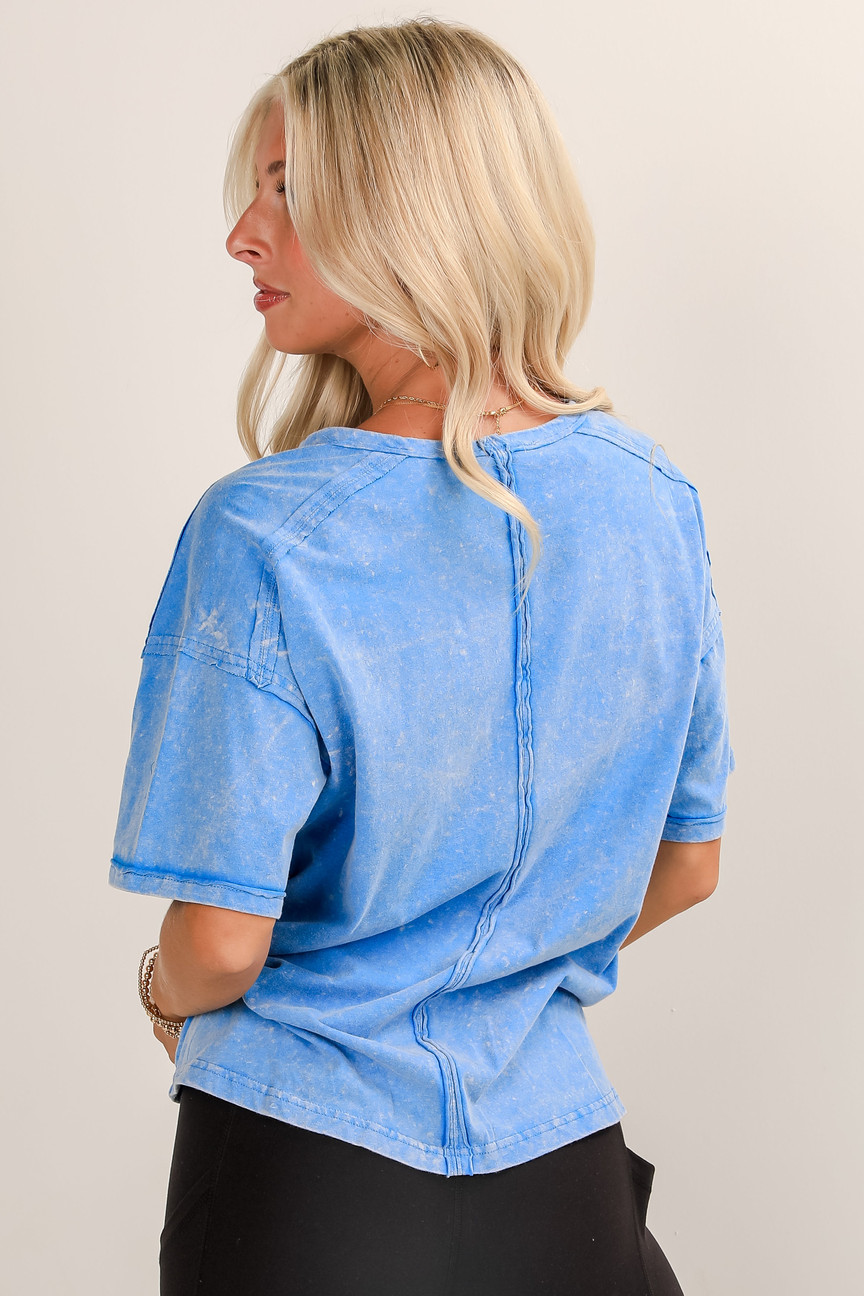 Woman wearing a blue denim shirt against a plain background
