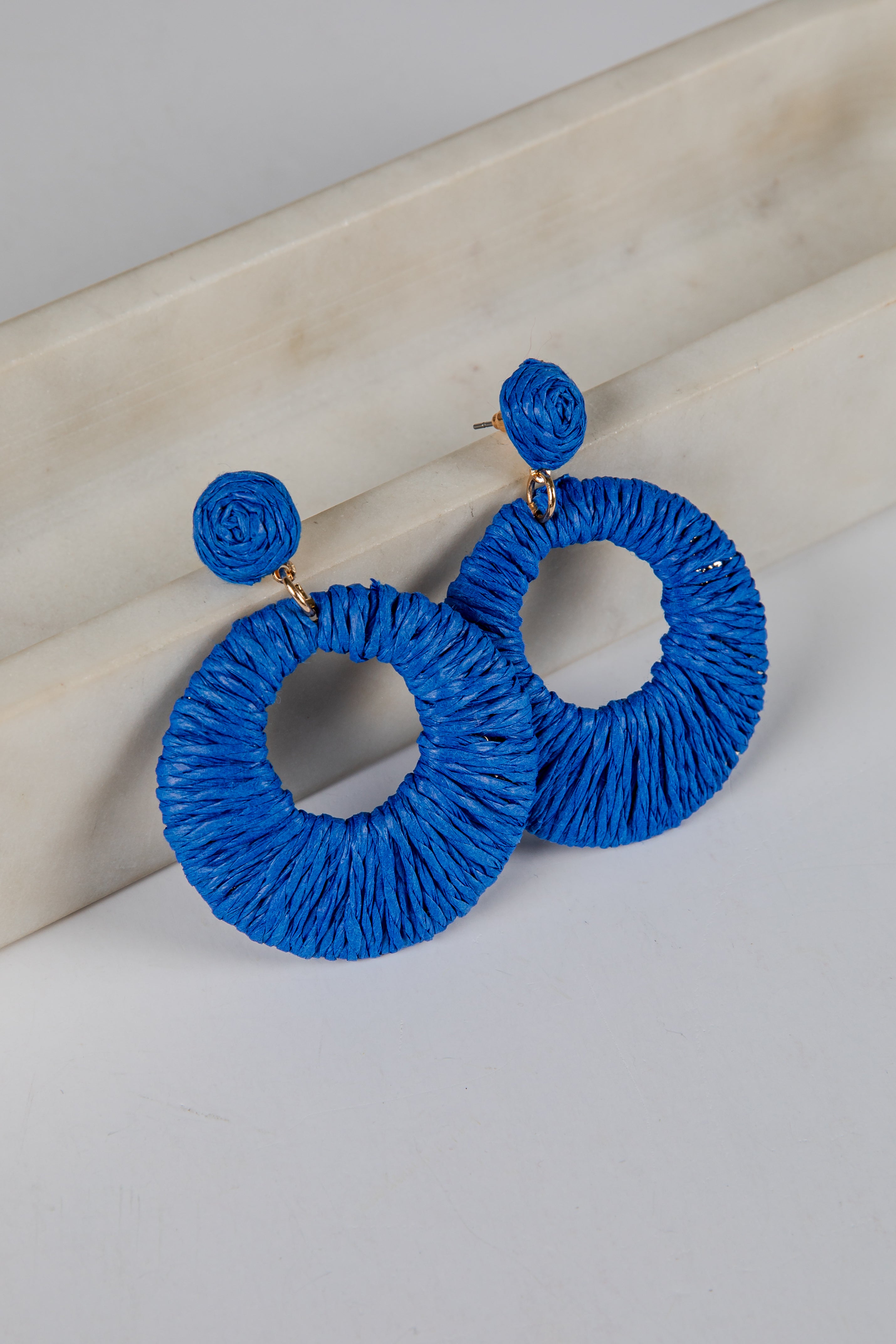Blue hoop earrings on a light wooden surface
