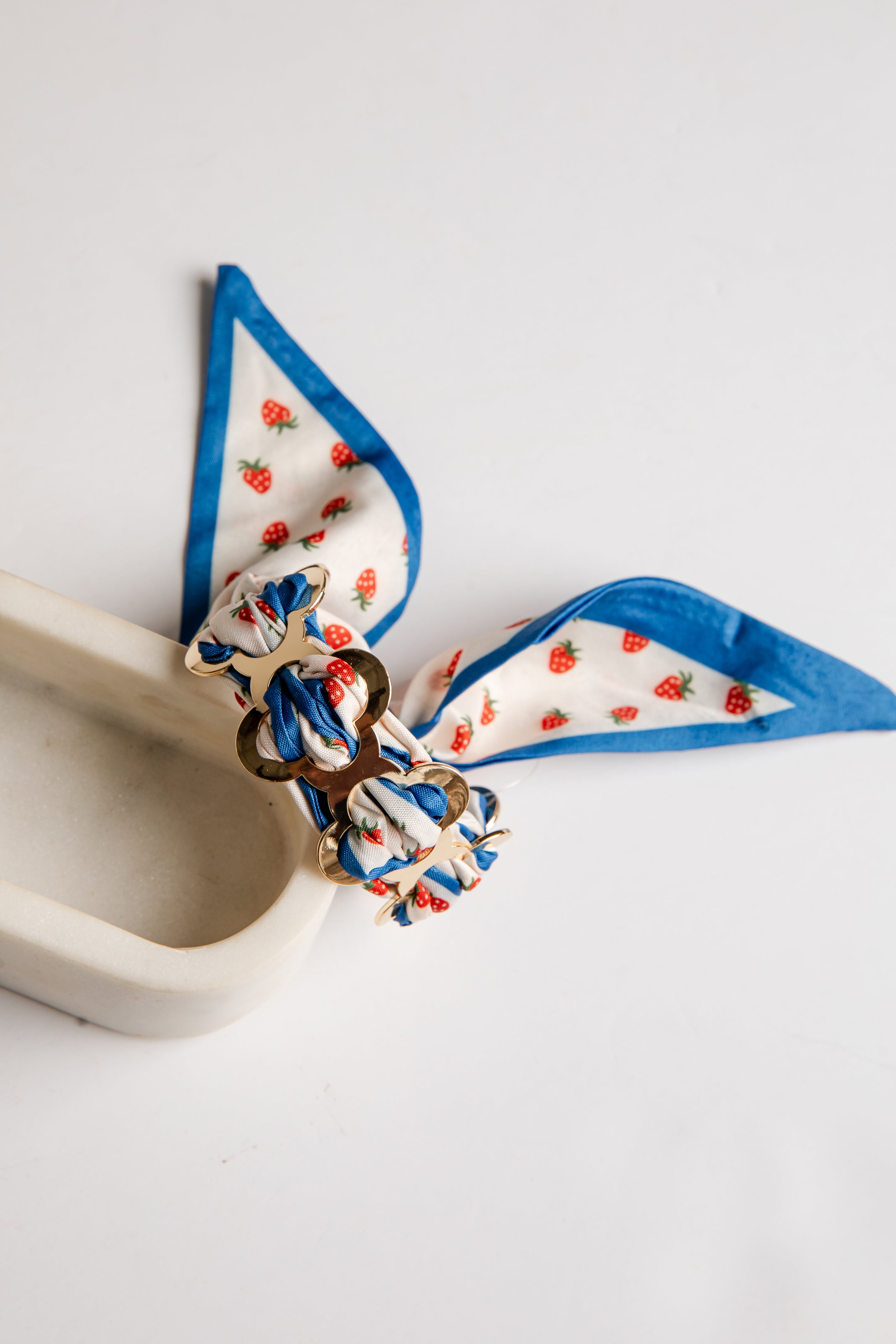 Decorative bow with blue ribbon and strawberry pattern on a white background