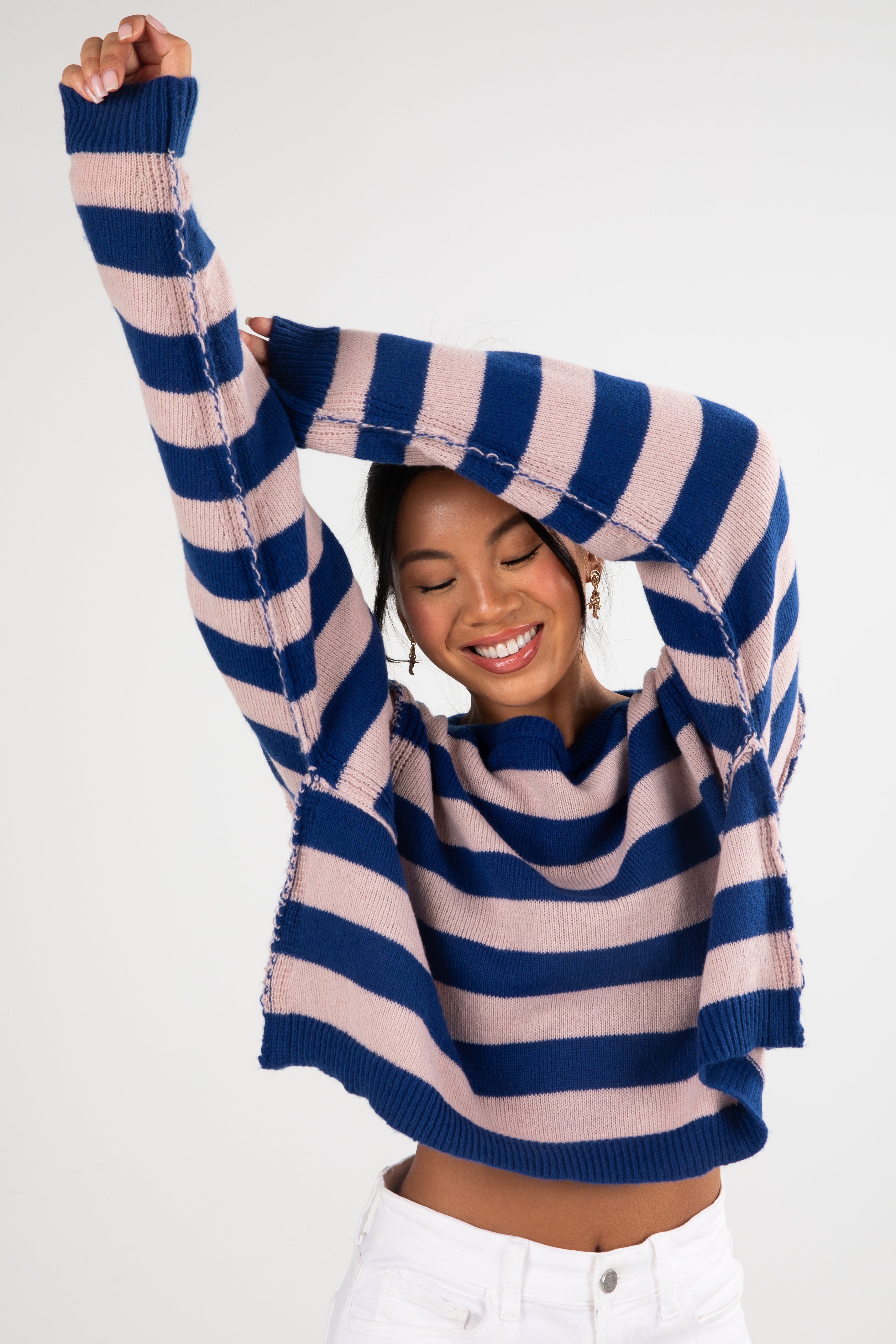 Person wearing a blue and pink striped sweater on a white background