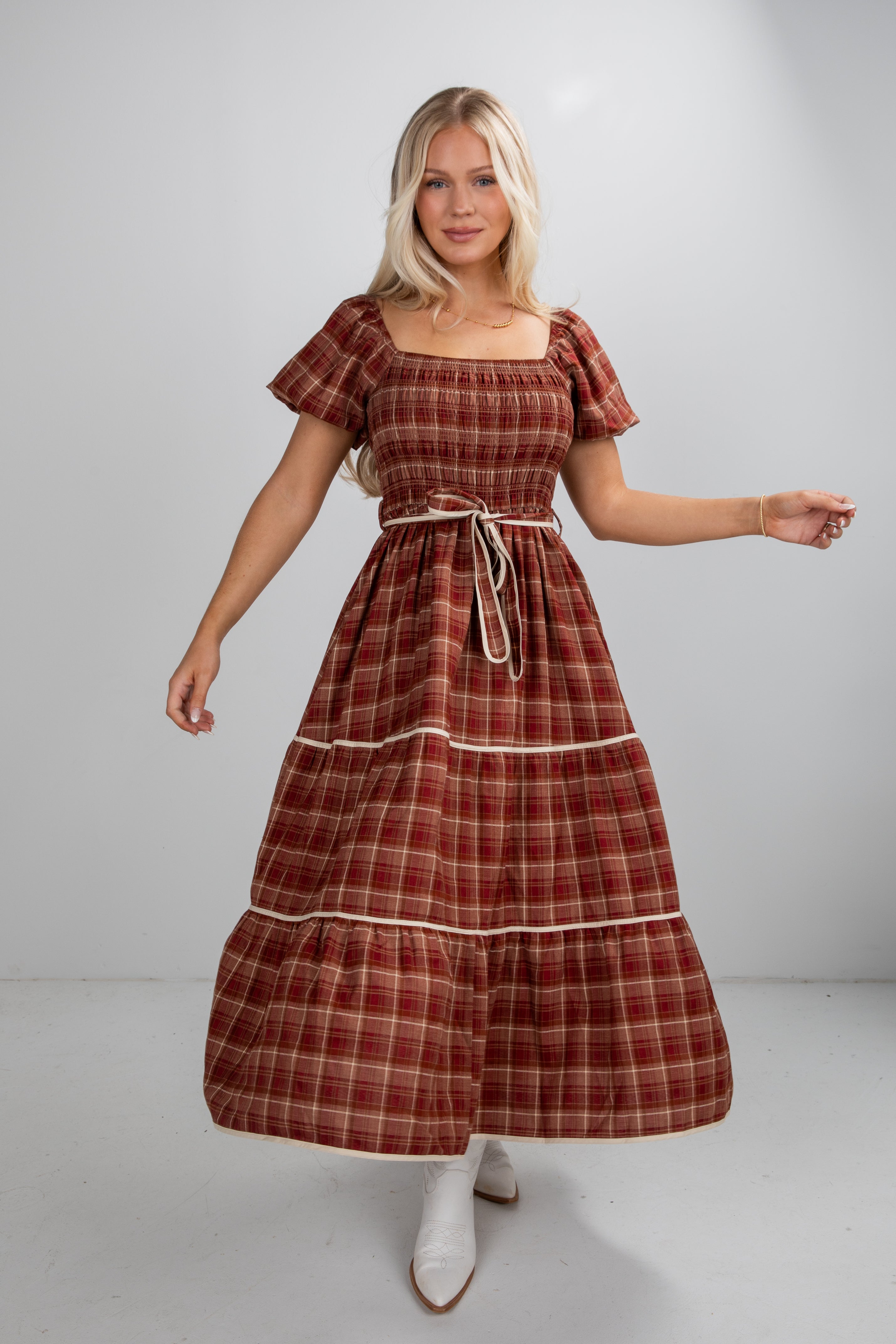 Woman wearing a plaid dress with a plain background