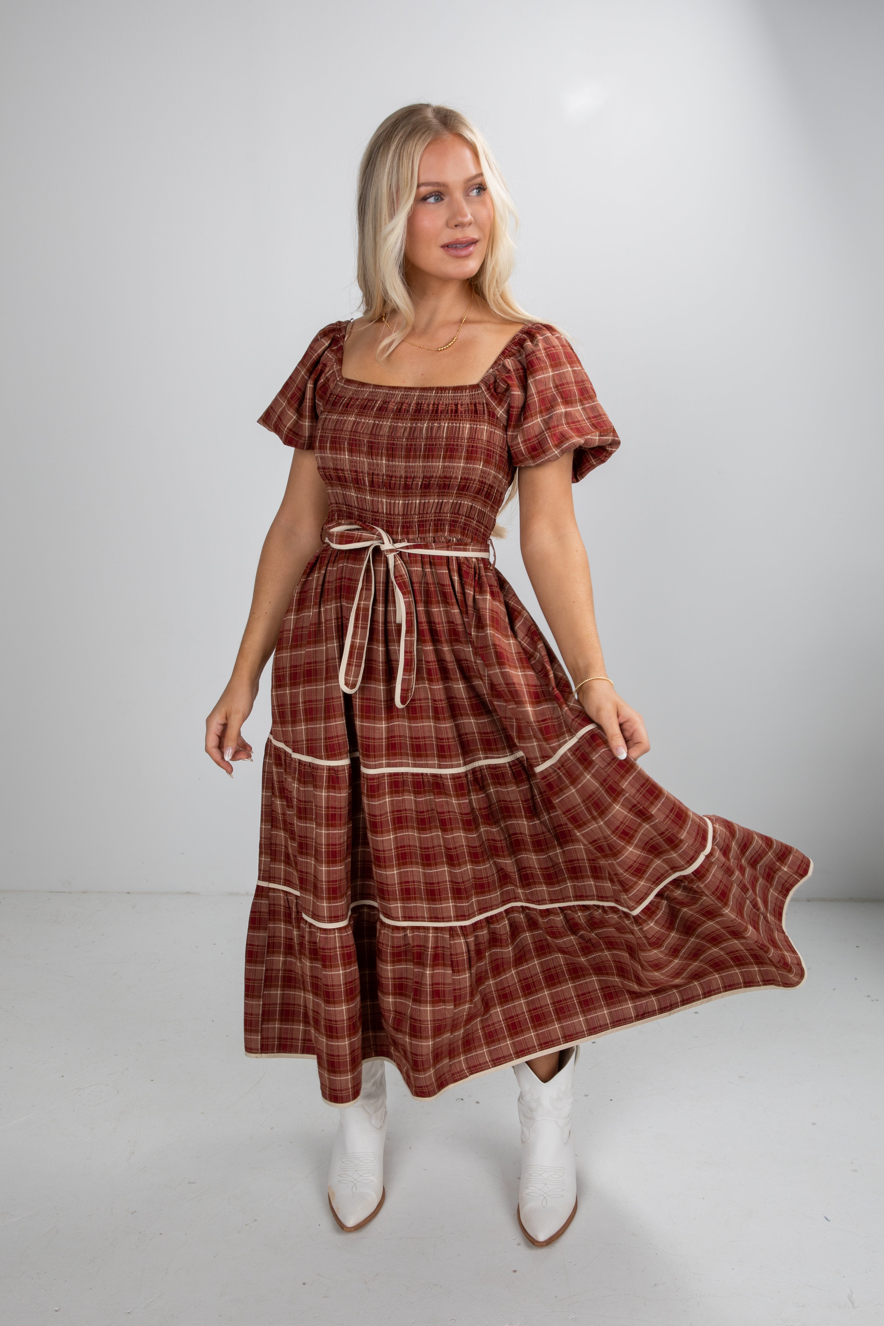 Woman wearing a plaid dress with a white background