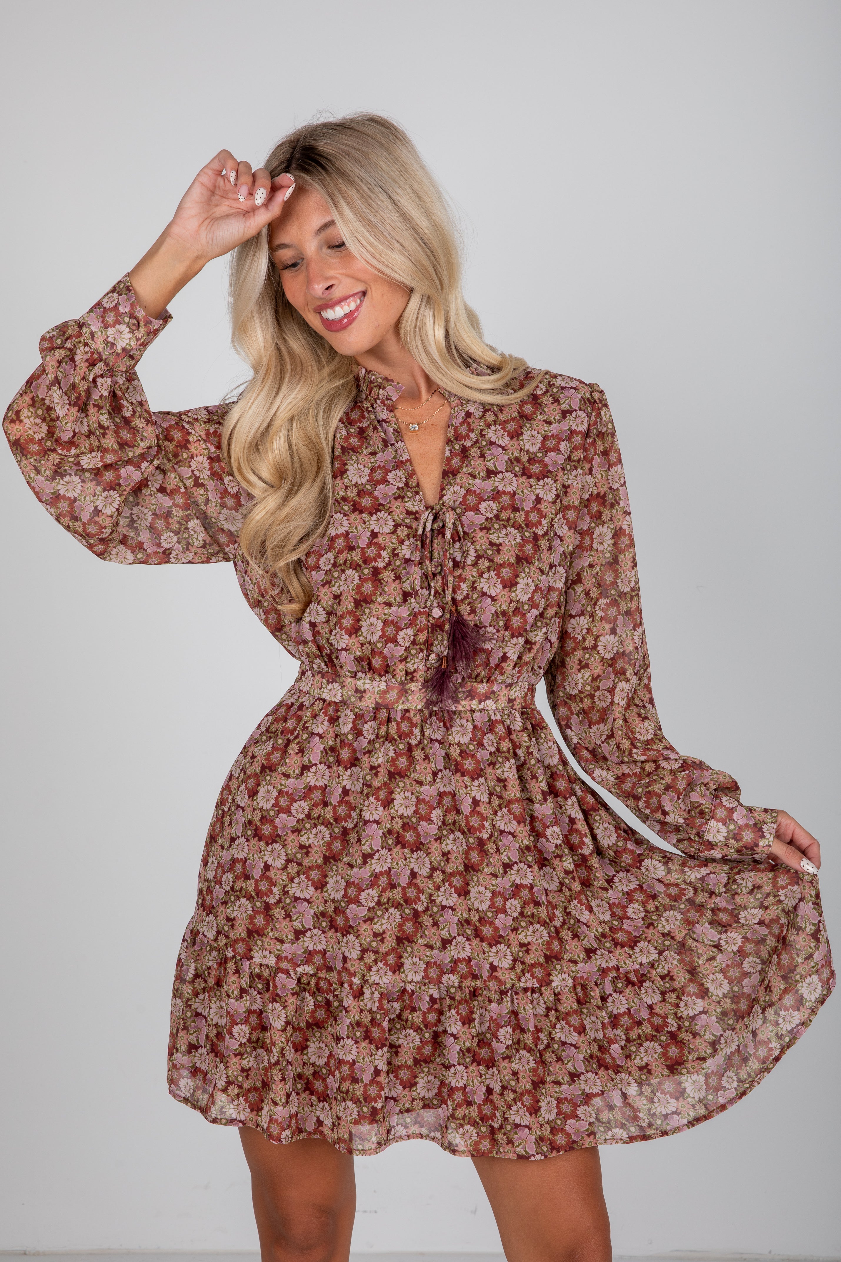 Woman wearing a floral dress against a plain background