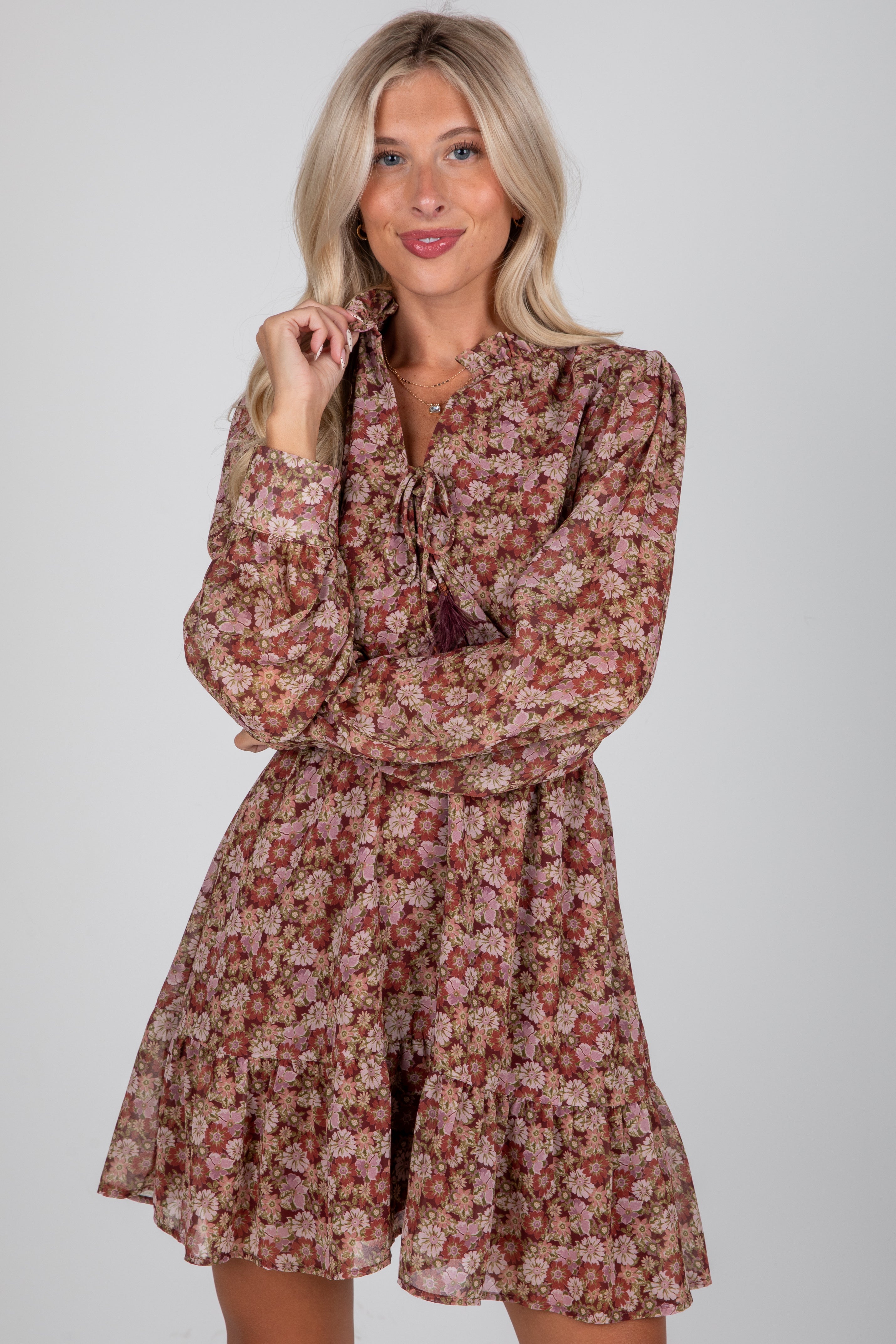 Woman wearing a floral dress against a plain background