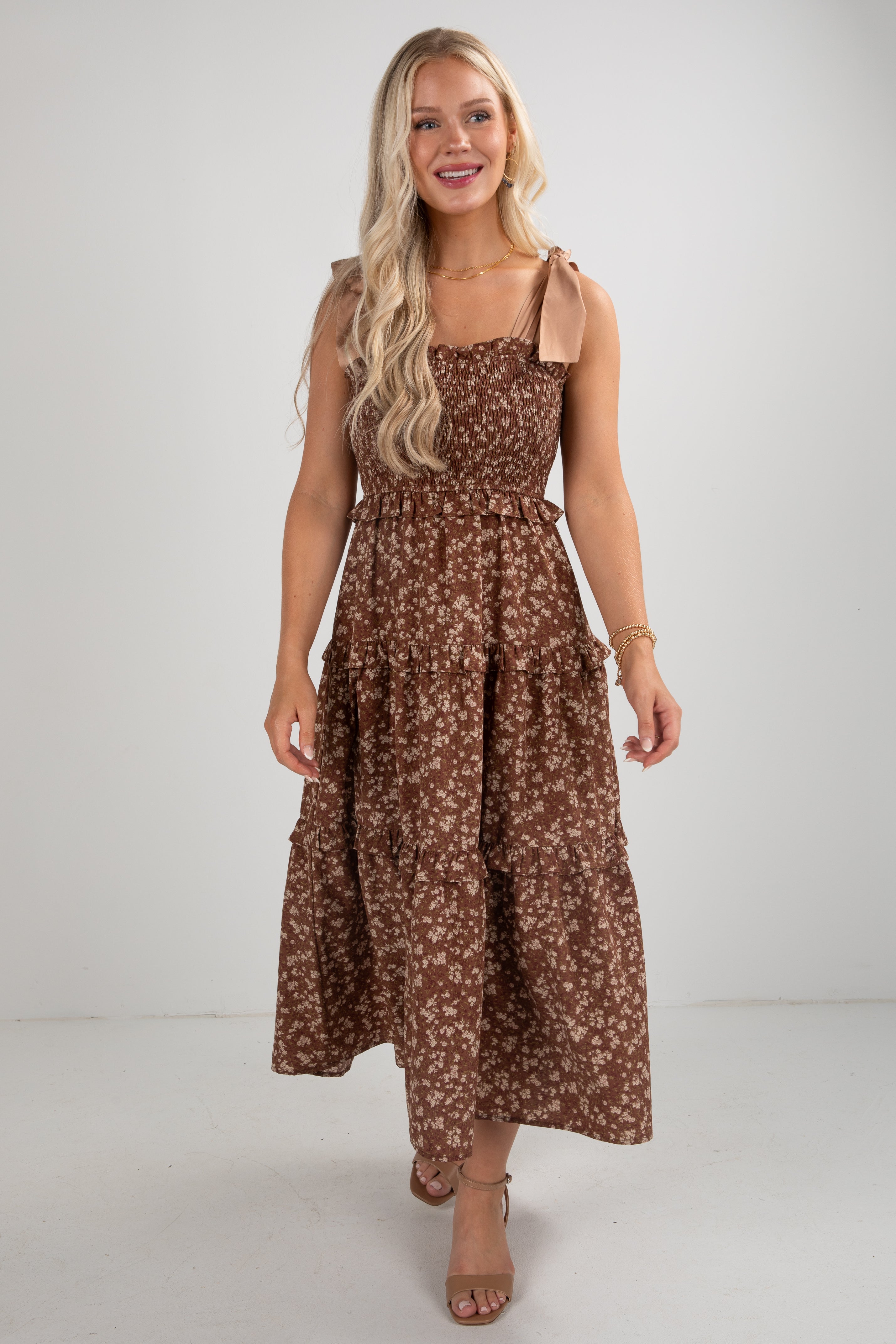 Woman wearing a brown floral dress on a white background